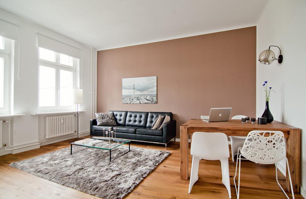 2-Zimmer-Wohnung Berlin #couchtisch #dielenboden #holztisch #wandfarbe #teppich #weißerstuhl #glascouchtisch #terracottawandfarbe ©White Apartments