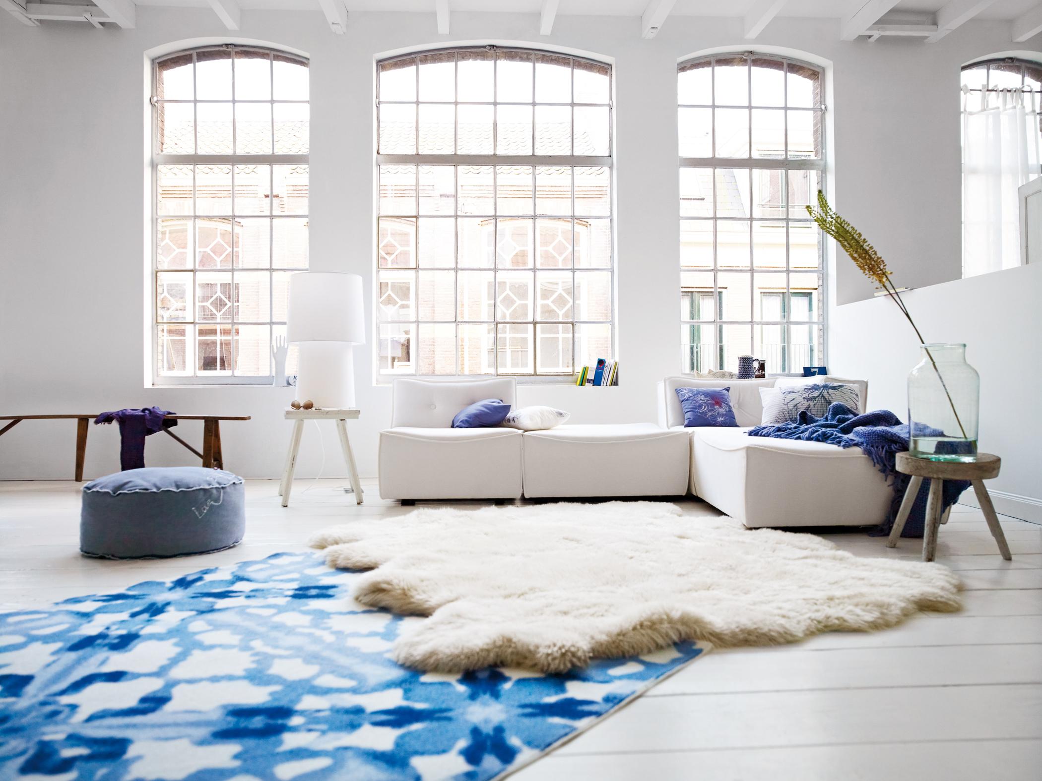 Aquarellfarbener Teppich im modernen Industrie-Chic #fensterfront #sitzbank #sofakissen #industriedesign #lammfell #hausgestaltung ©Esprit Home