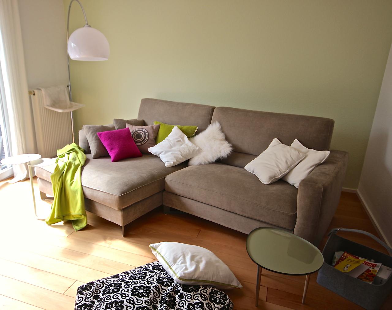 Gemütliches Sofa vor grüner Wand #couchtisch #dielenboden #wandfarbe #ecksofa #stehlampe #sofakissen #grünewandfarbe ©Foto Gerardina Pantanella