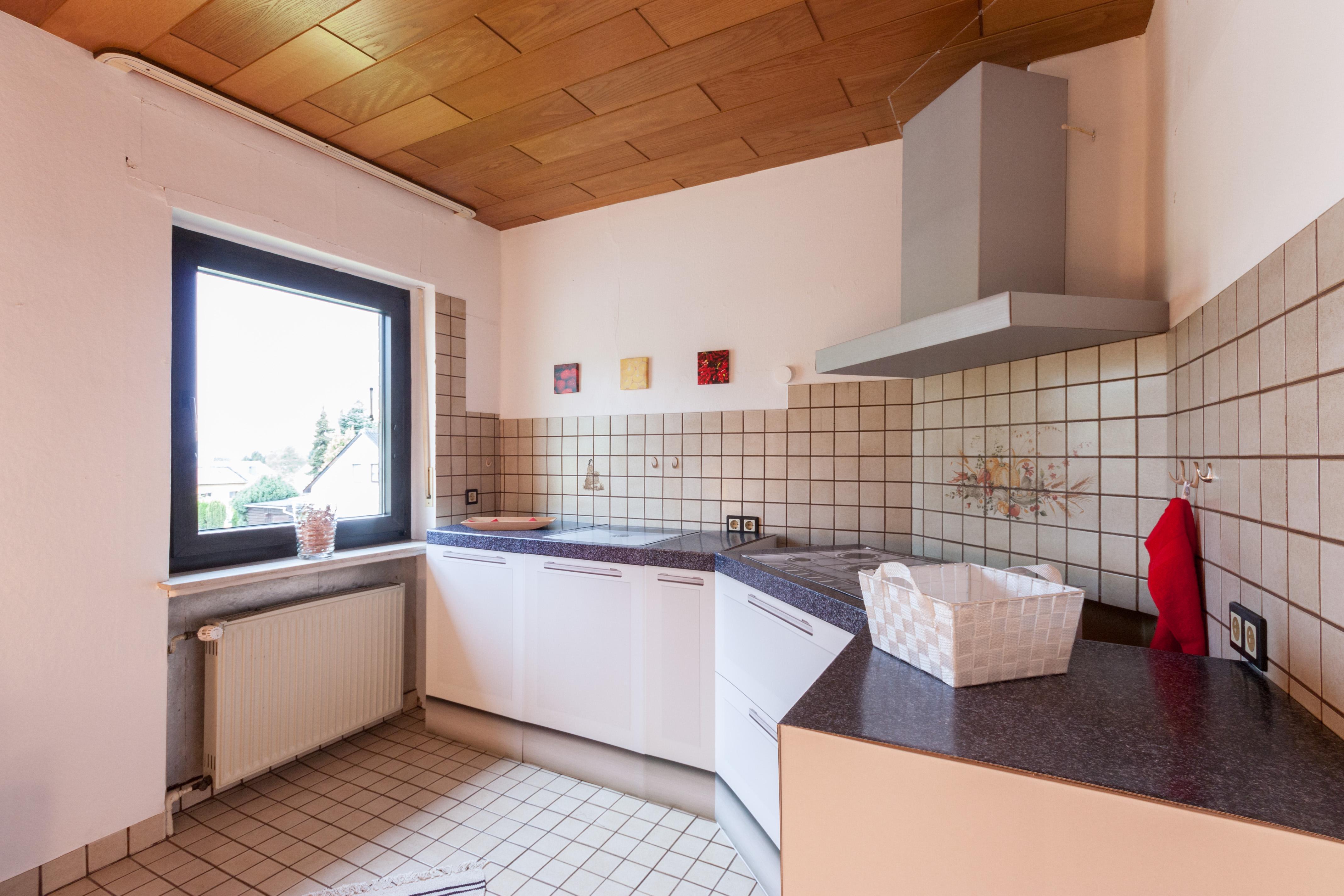 Küche - nachher #küche #holzdecke #wandfliesen #dunklerfensterrahmen ©IMMOTION Home Staging / Florian Gürbig