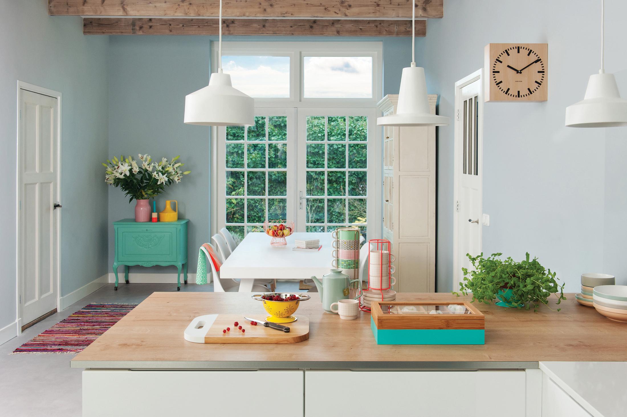 Küche in hellen gedeckten Farben #wandfarbe #arbeitsplatte #kommode #deckenbalken #wanddeko #wanduhr #küchentresen #weißerküchenschrank #hellblauewandfarbe ©Present Time