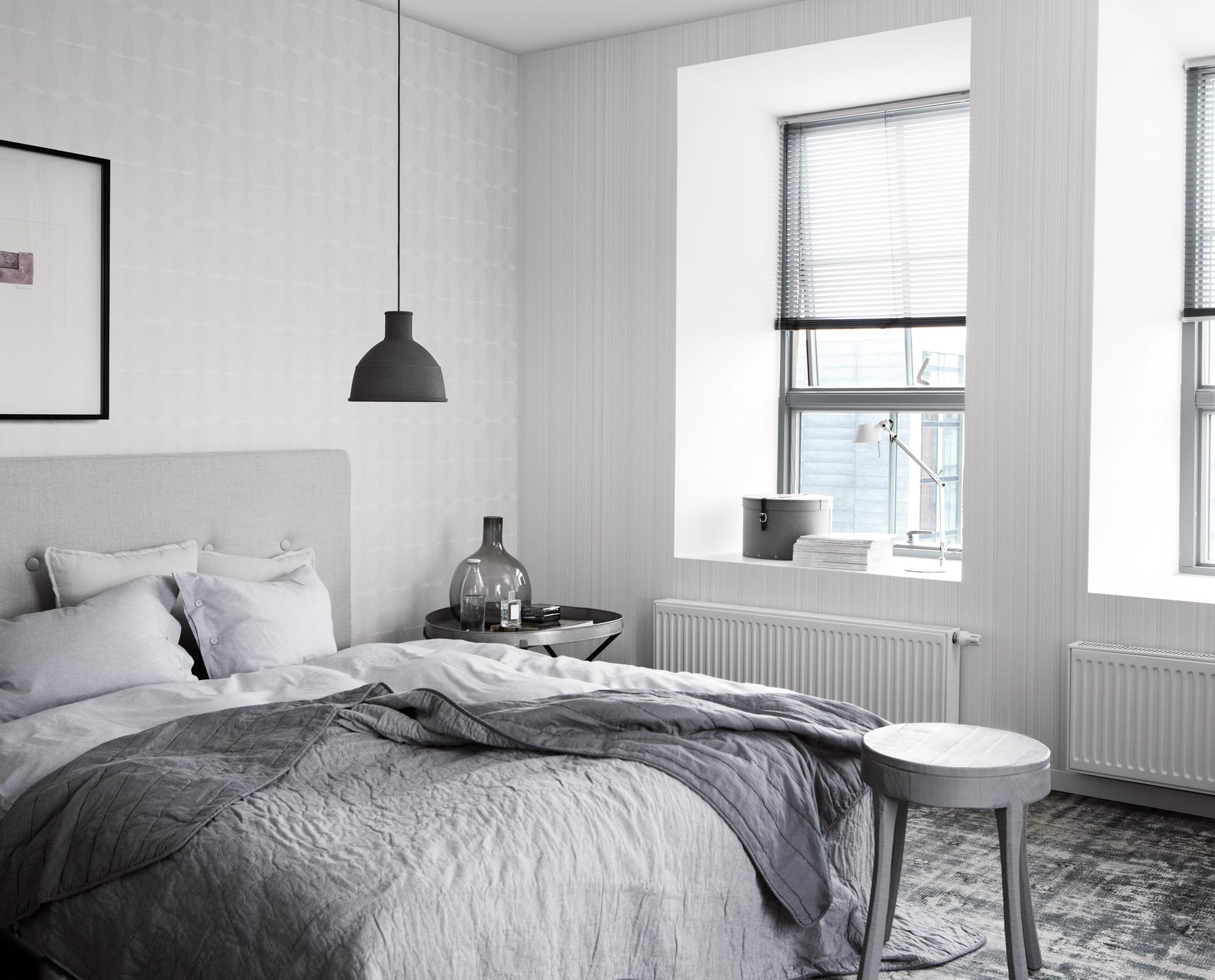 Modernes Schlafzimmer in Grau-Weiß #bilderrahmen #grauerhocker #schwarzehängeleuchte ©Eco Wallpaper