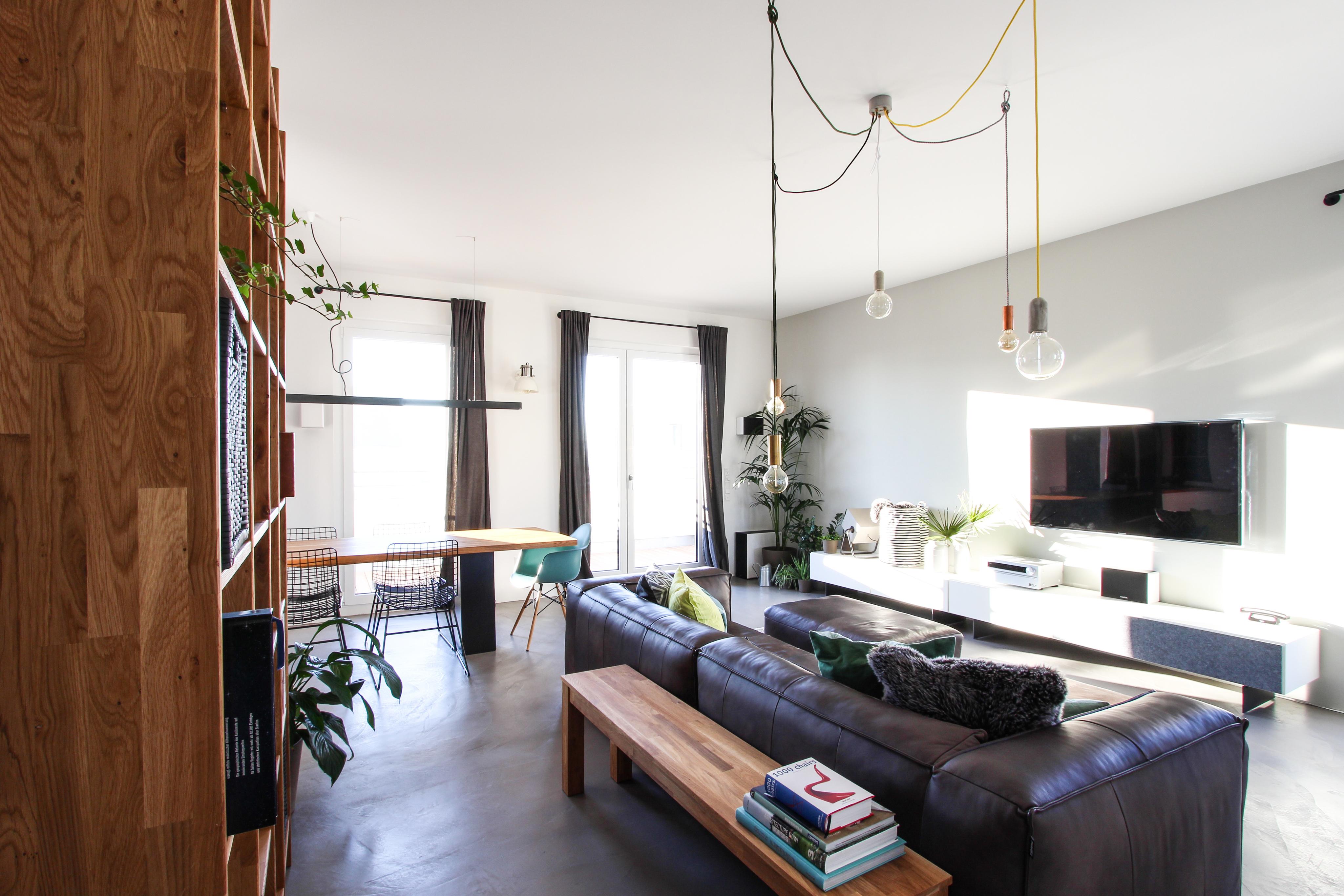 Offenes Wohnzimmer mit Ledercouch #holzbank #pendelleuchte ©EXTRAVIEL office & home design
