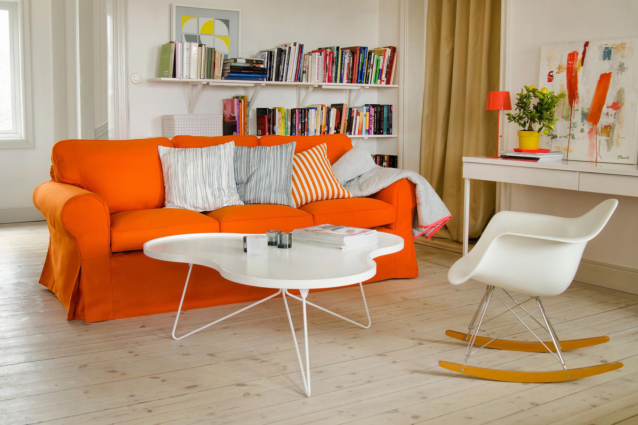 Orangefarbenes Sofa im Wohnzimmer #couchtisch #regal #schreibtisch #kissen #ikea #schaukelstuhl #sofa #tischlampe #weißercouchtisch #orangefarbenessofa ©Bemz