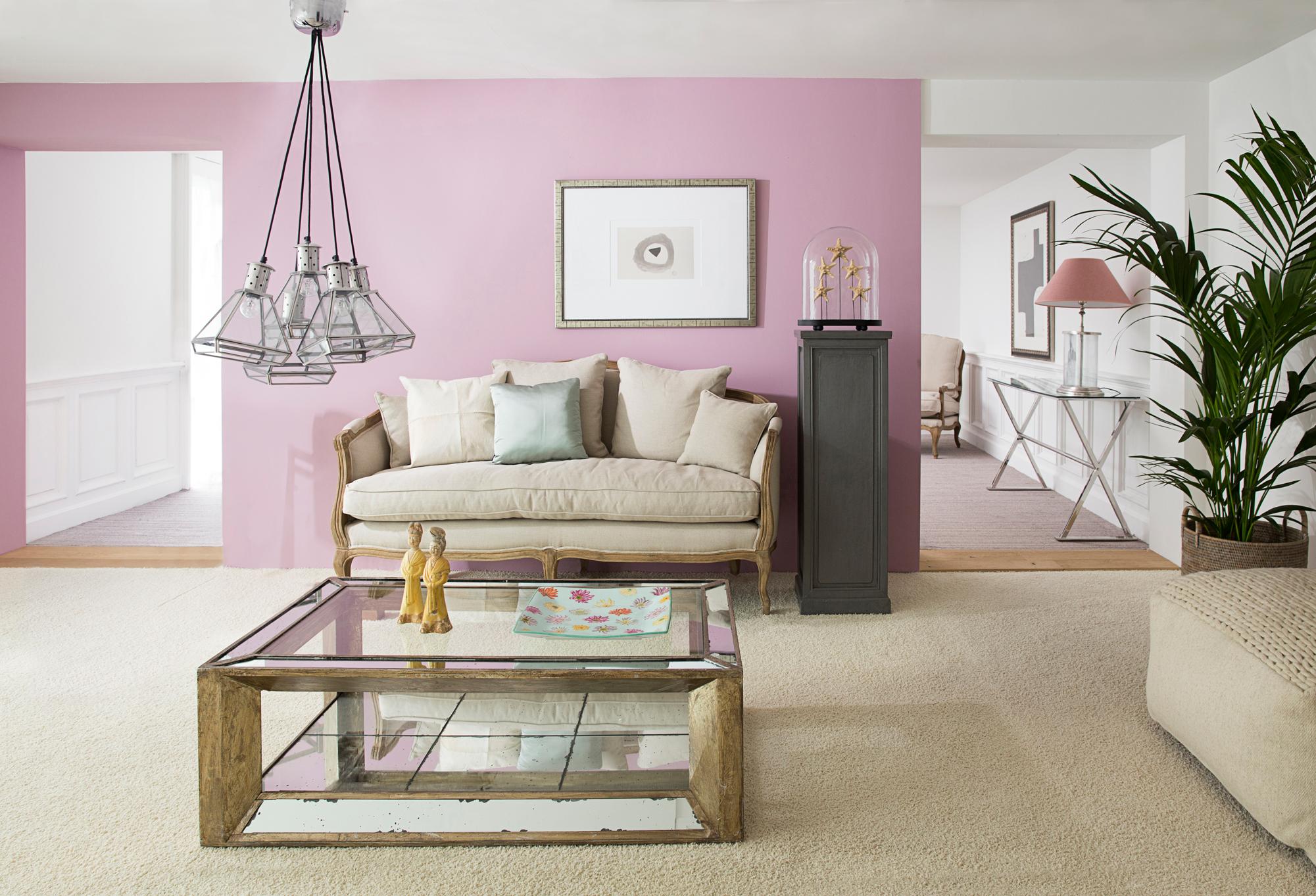 Rosa Wandfarbe bringt frische Akzente #couchtisch #wohnzimmer #pendelleuchte #sofa #glascouchtisch #zimmergestaltung ©Flamant