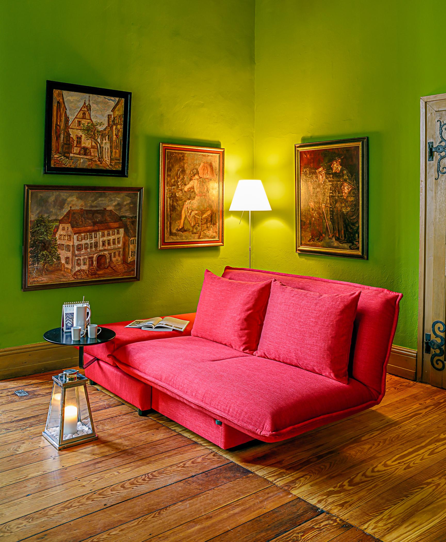 Schlafsofa in Rot #beistelltisch #wohnzimmer #stehlampe #sofa #lampe #rotessofa #grünewandfarbe ©Franz Fertig
