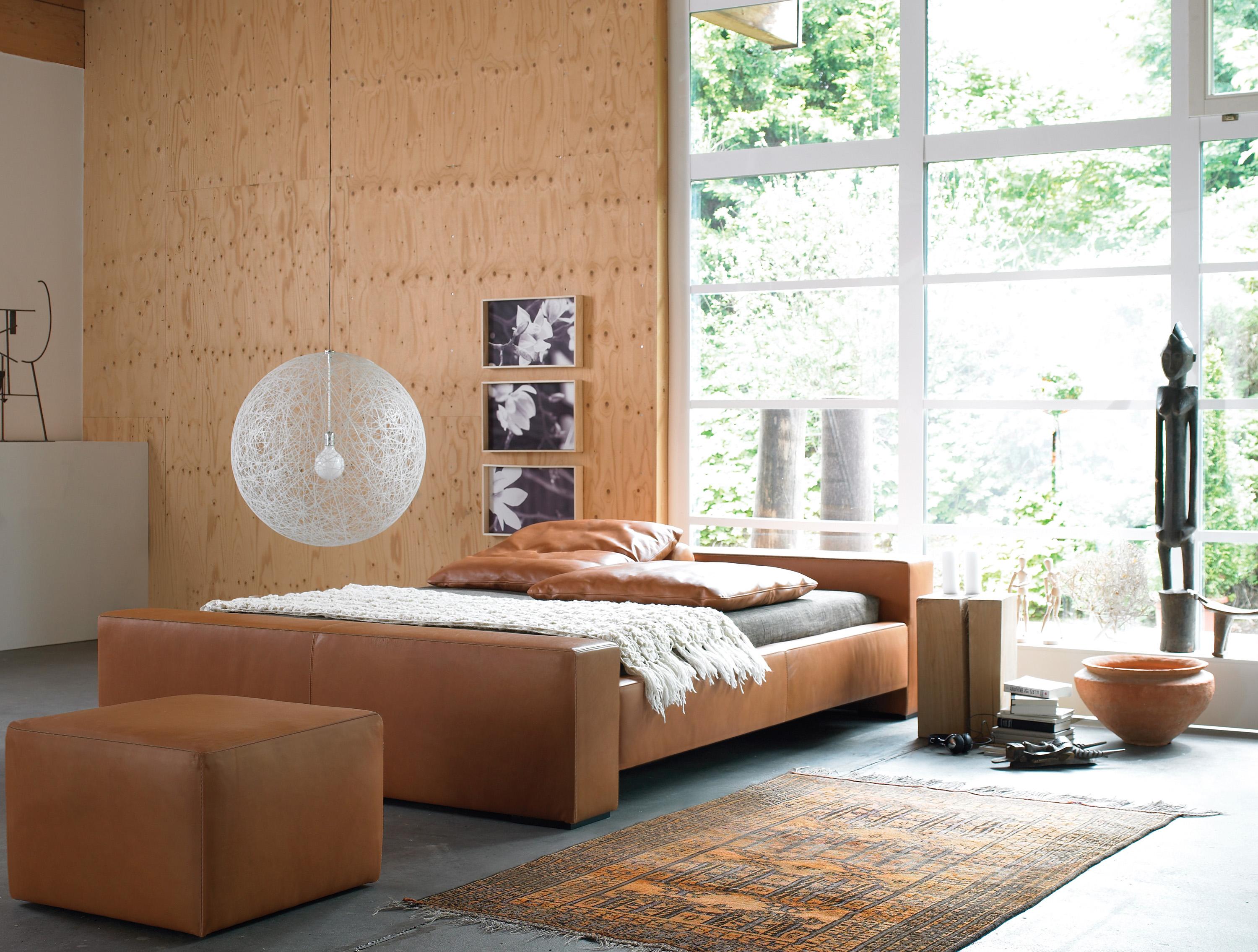 Schlafzimmergestaltung in natürlichen Holztönen #bett #teppich #wandverkleidung #hängeleuchte #wandbild #holzwandverkleidung #panoramafenster #zimmergestaltung ©Möller Design