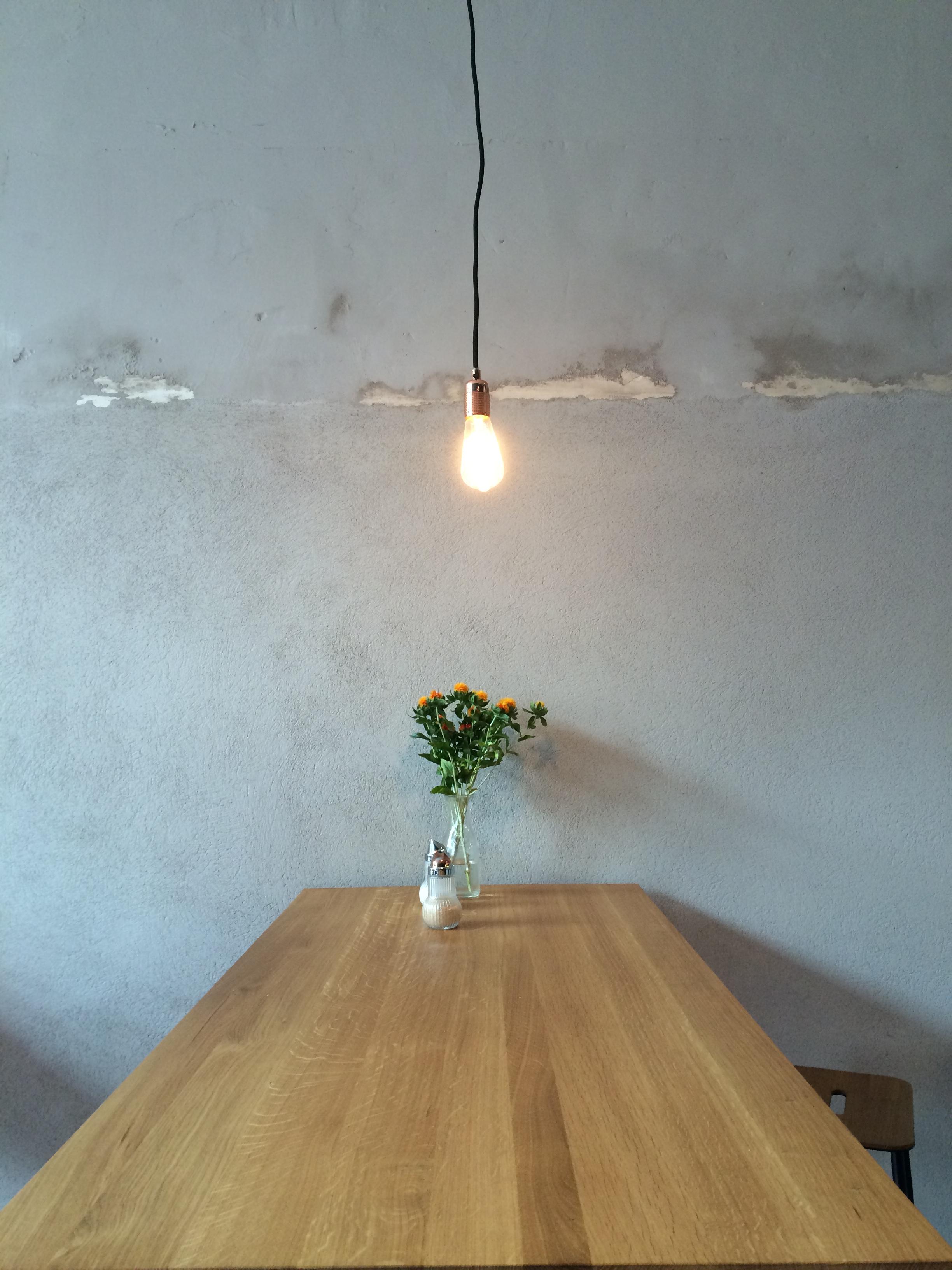#upcyclinglampe im Café. Schlicht aber wirkungsvoll. #glühbirne #betonwand #beton #holztisch #upcycling