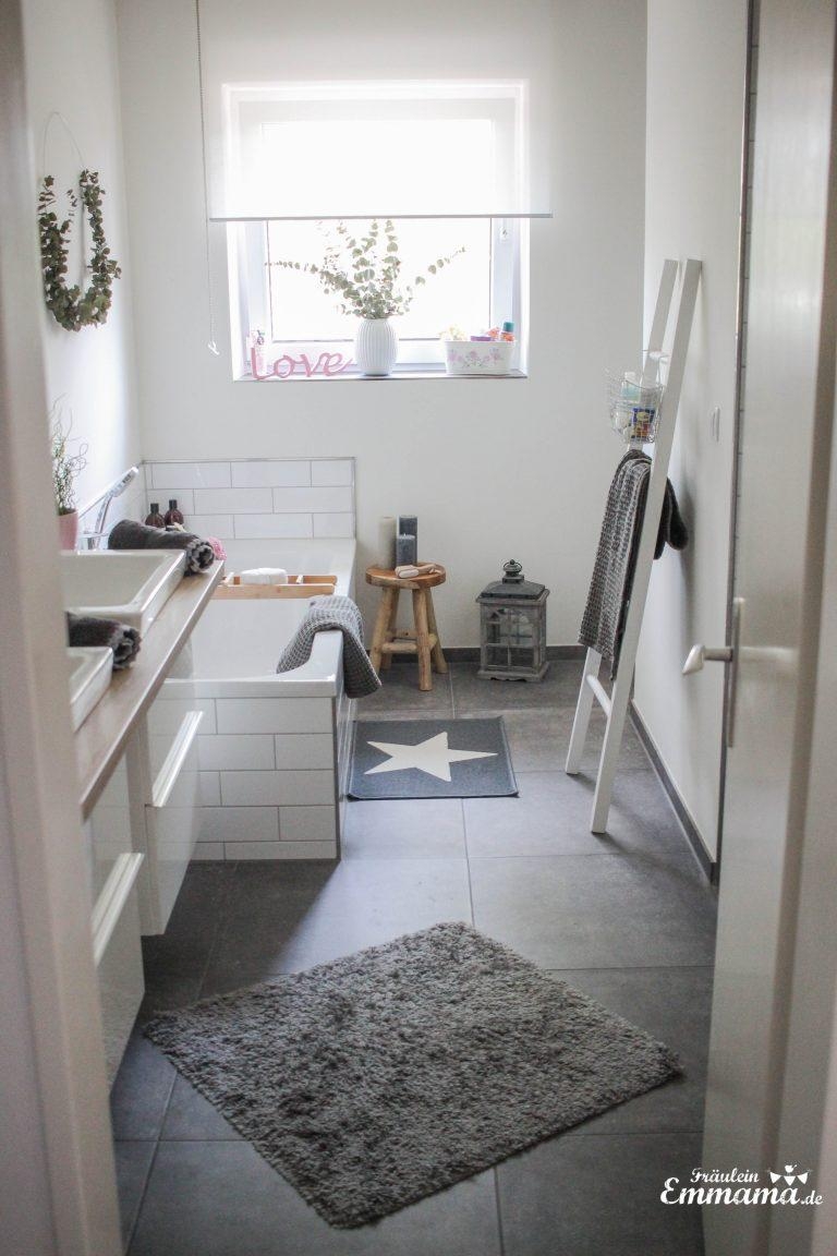 Willkommen im Badezimmer in Grau und weiß. 
Holzakzente verleihen Gemütlichkeit 