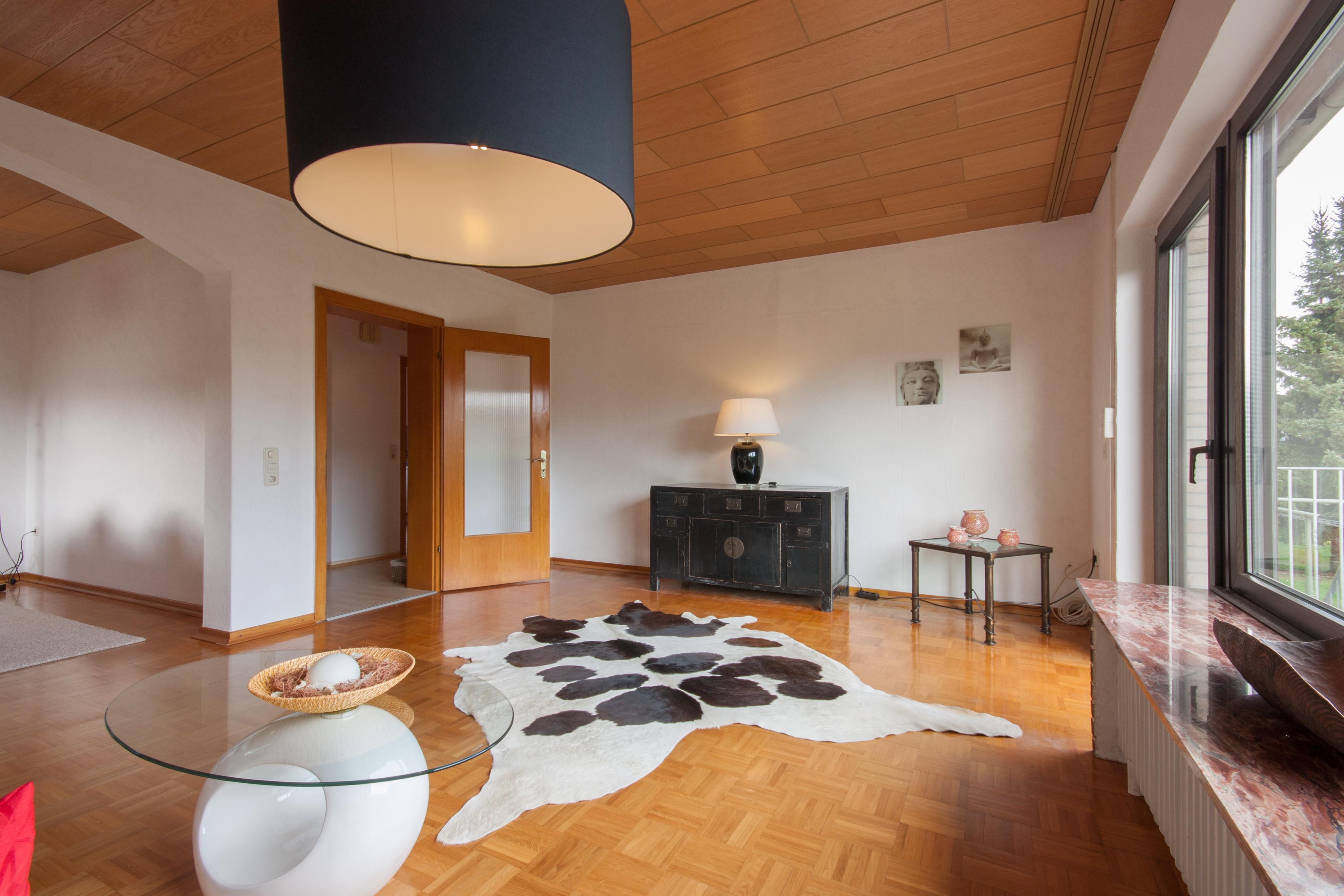 Wohnzimmer - nachher #couchtisch #beistelltisch #wohnzimmer #holzdecke #kommode #kuhfell ©IMMOTION Home Staging / Florian Gürbig
