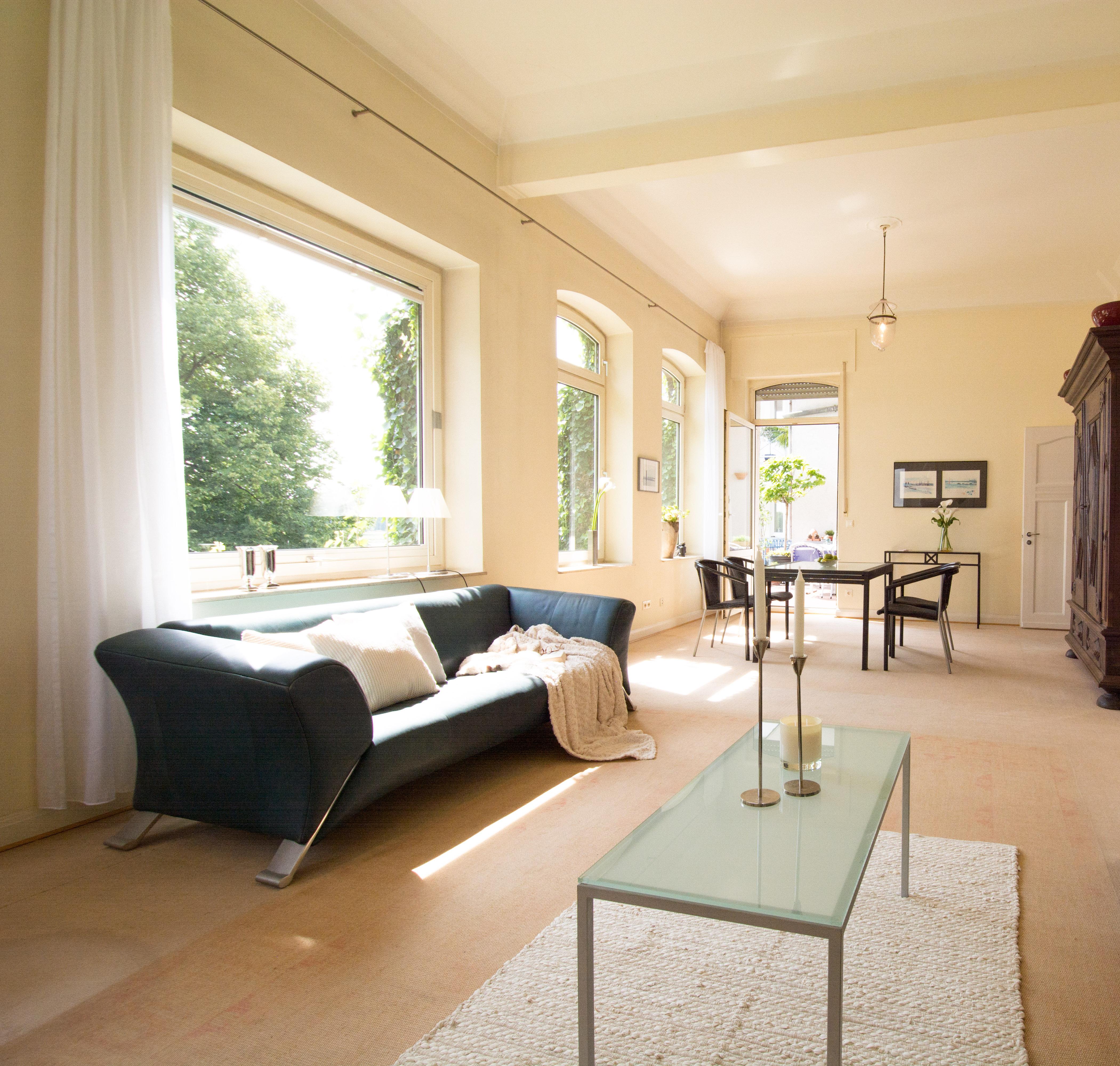 Wohnzimmer #couchtisch #glastisch #sofakissen #sofa #blauessofa #glascouchtisch #großesfenster ©Luna Home Staging