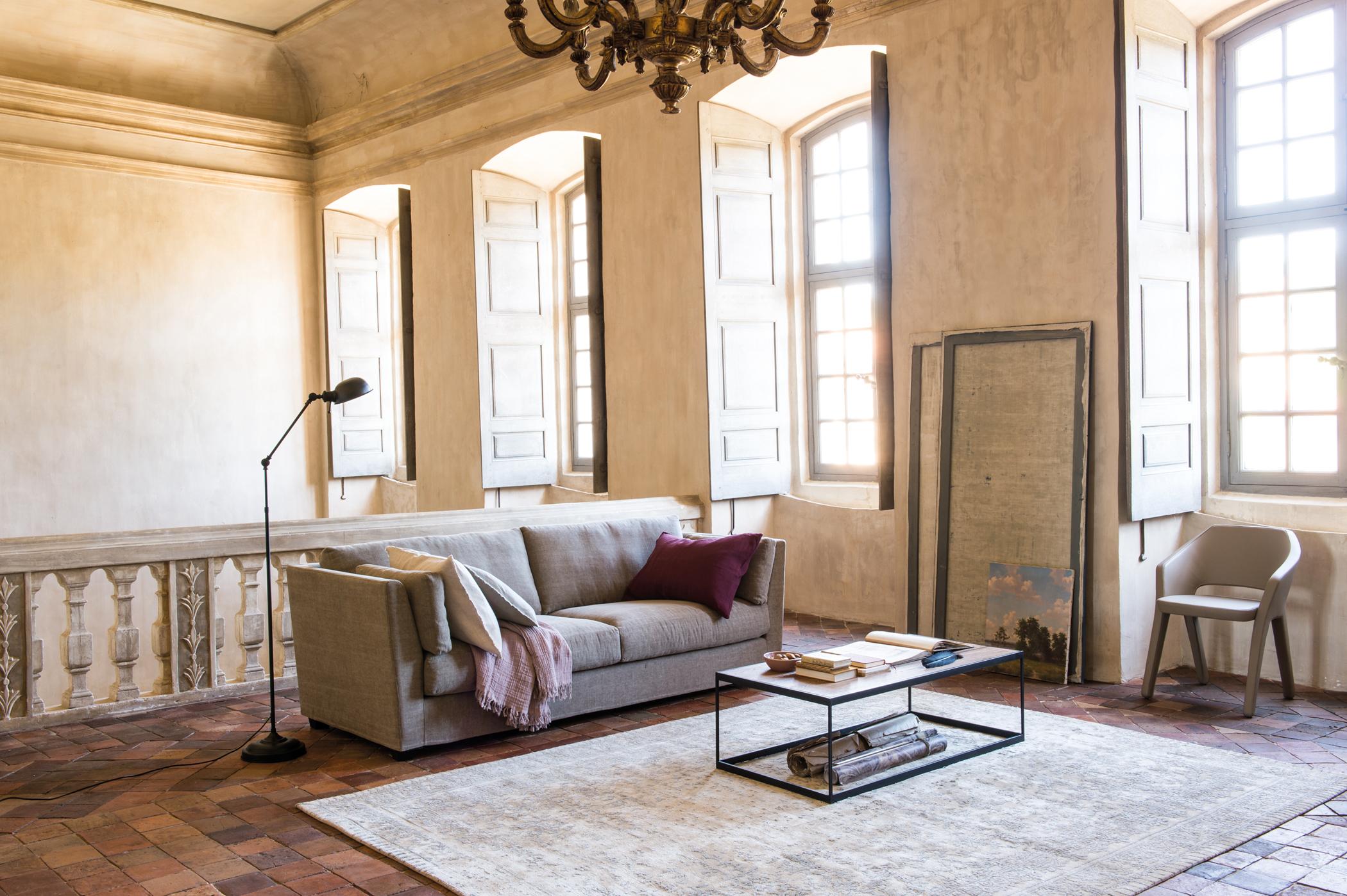 Wohnzimmer mit Galerie-Flair #stuhl #couchtisch #teppich #kronleuchter #stehlampe #tagesdecke #sofa #metallcouchtisch #lampe ©Pfister