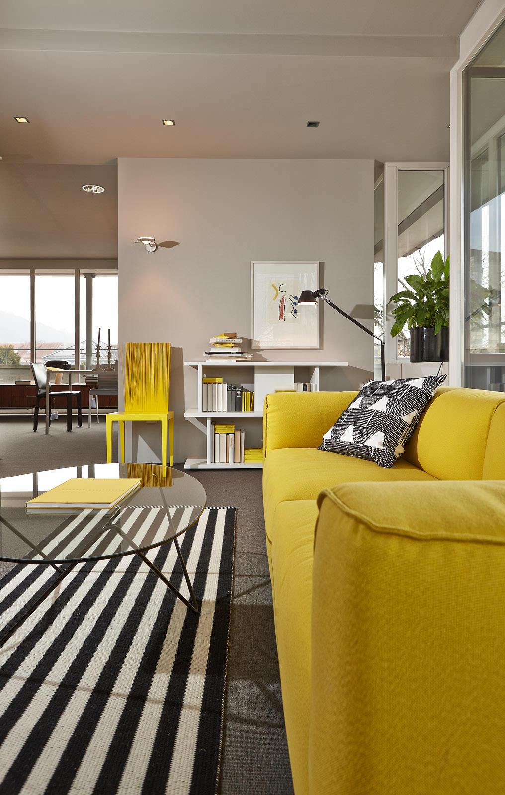Wohnzimmer mit gelben Hinguckern #stuhl #couchtisch #regal #teppich #glastisch #stehlampe #sofa #glascouchtisch #gelbessofa #wohnzimmergestaltung ©Seipp Wohnen