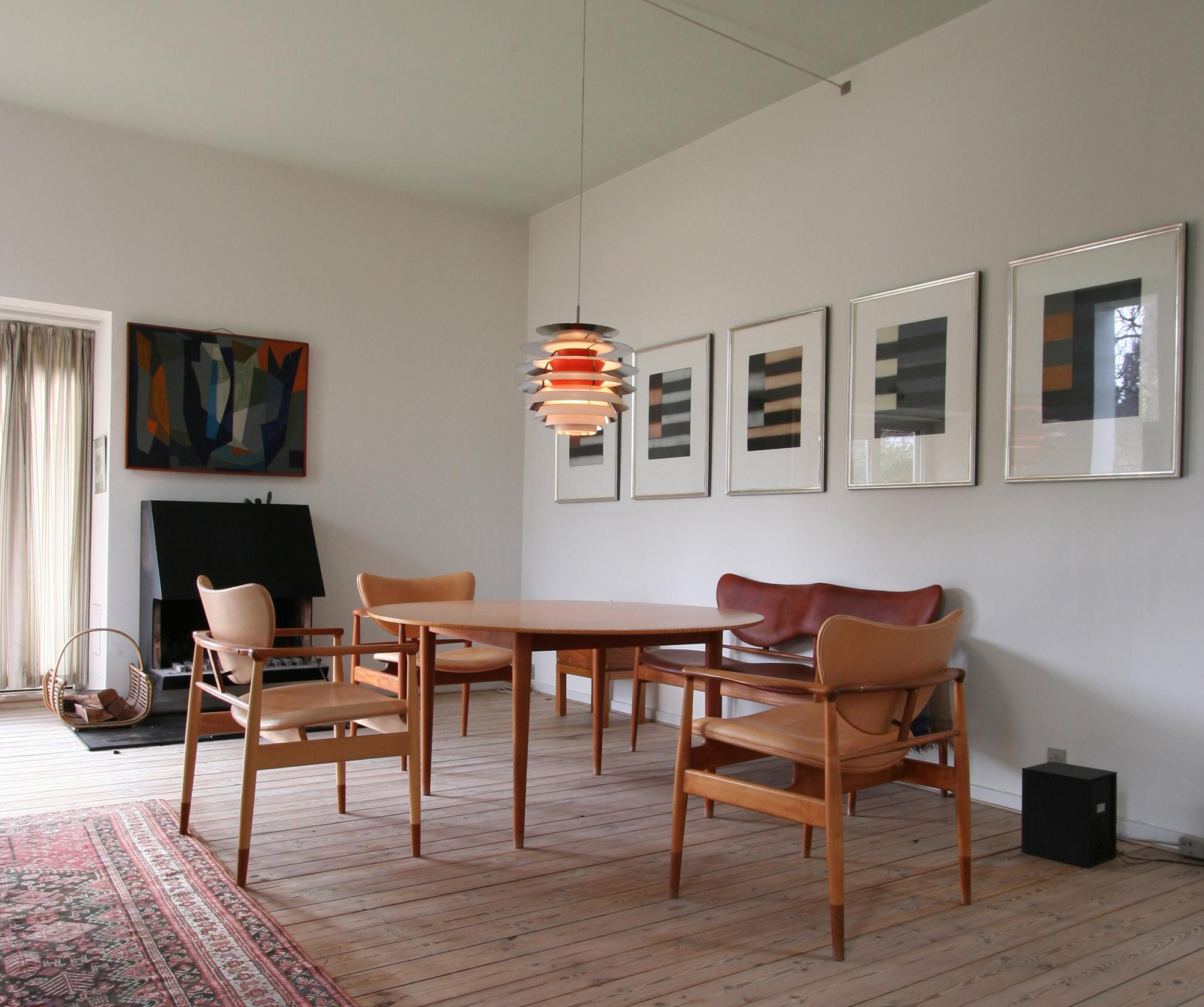 Designklassiker im Wohnzimmer #kamin #sessel #pendelleuchte #tisch ©Onecollection / Finn Juhl