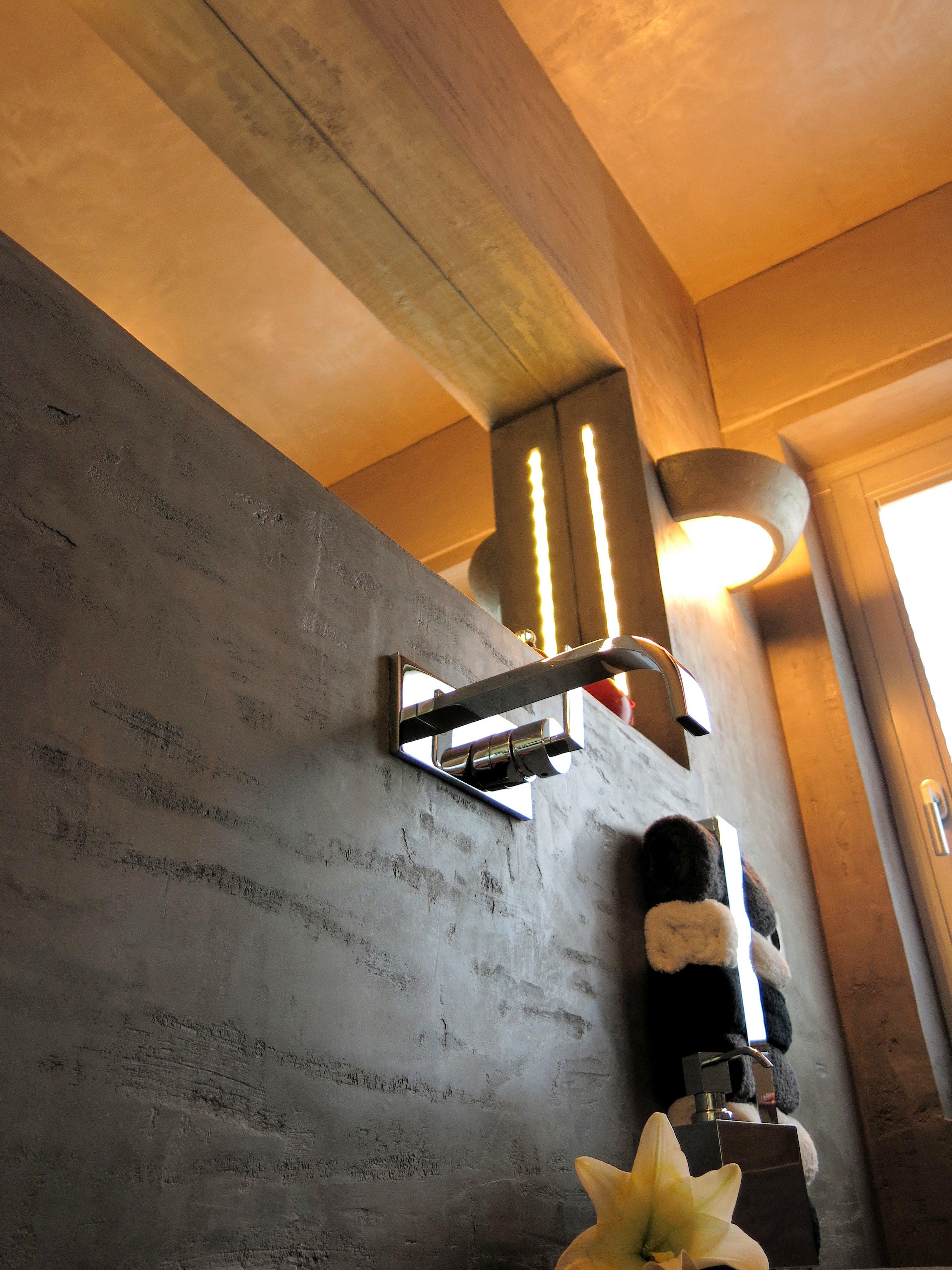 Eine moderne Badezimmer Wandgestaltung in unserem chaby Travertin #wandleuchte #handtuchhalter #grauewandfarbe #fliesenlosesbad #wandgestaltungbadezimmer ©www.wandmanufaktur.de