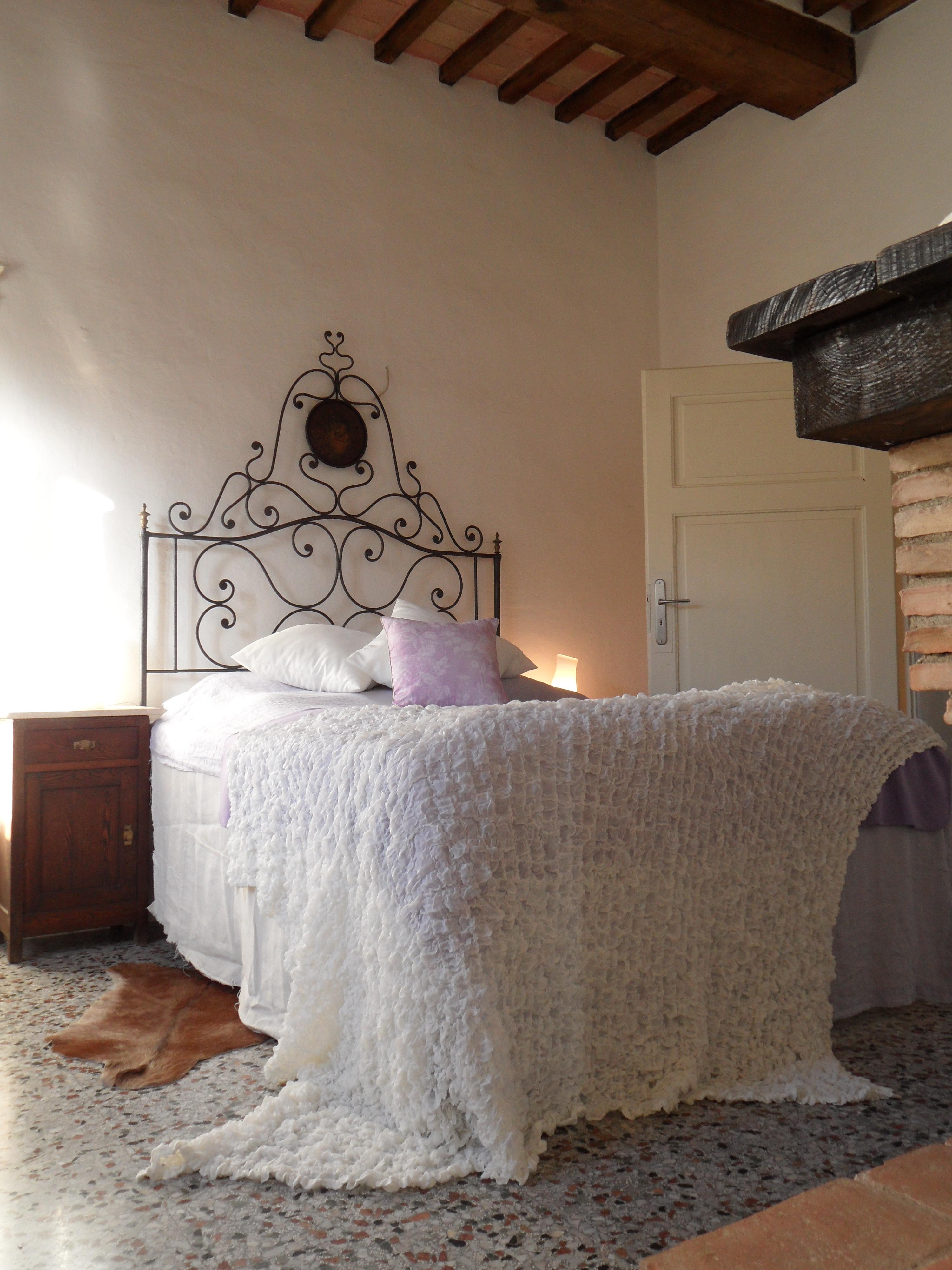 Einladender Schlafplatz im Gästeschlafzimmer #bett #tagesdecke #steinfußboden #metallbett #bettüberwurf ©Yvonne Heinemann