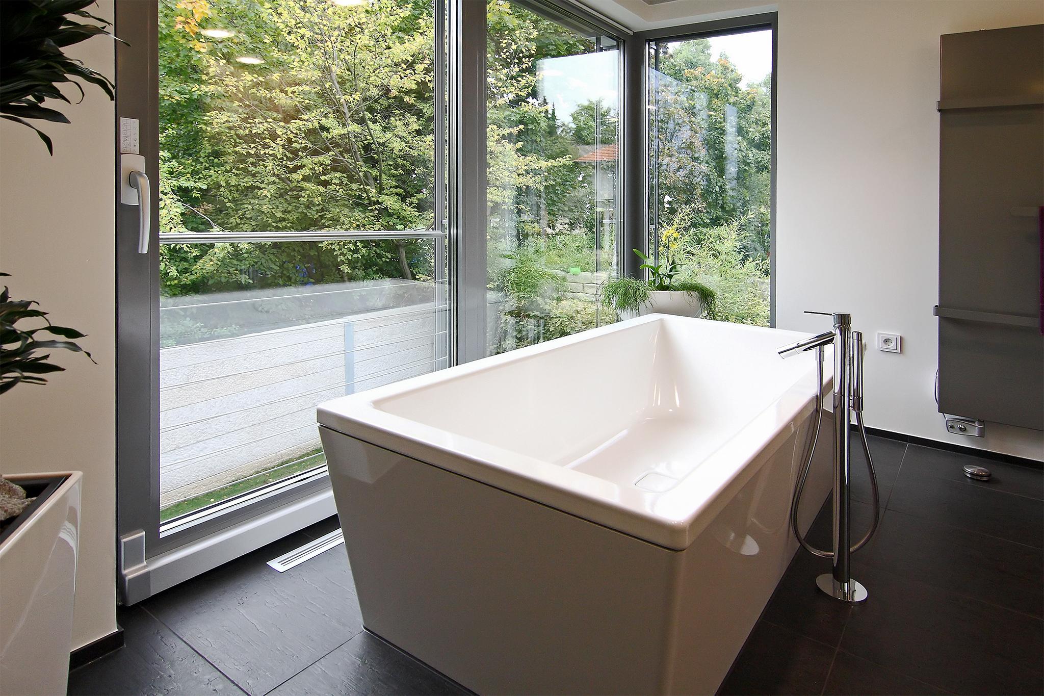 Freistehende Badewanne mit Blick ins Grüne #freistehendebadewanne #bodentiefefenster ©HEIMWOHL GmbH