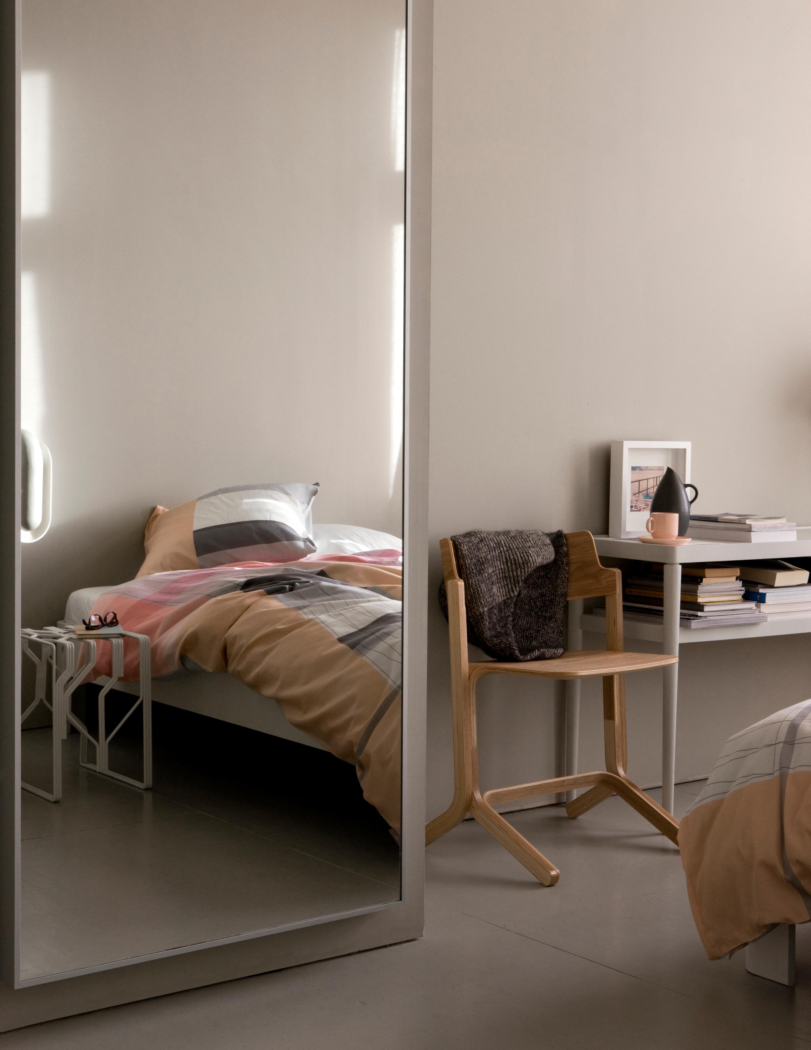 Gemusterte Bettwäsche und Holzstuhl im Schlafzimmer #beistelltisch #holzstuhl #spiegelschrank ©Hay