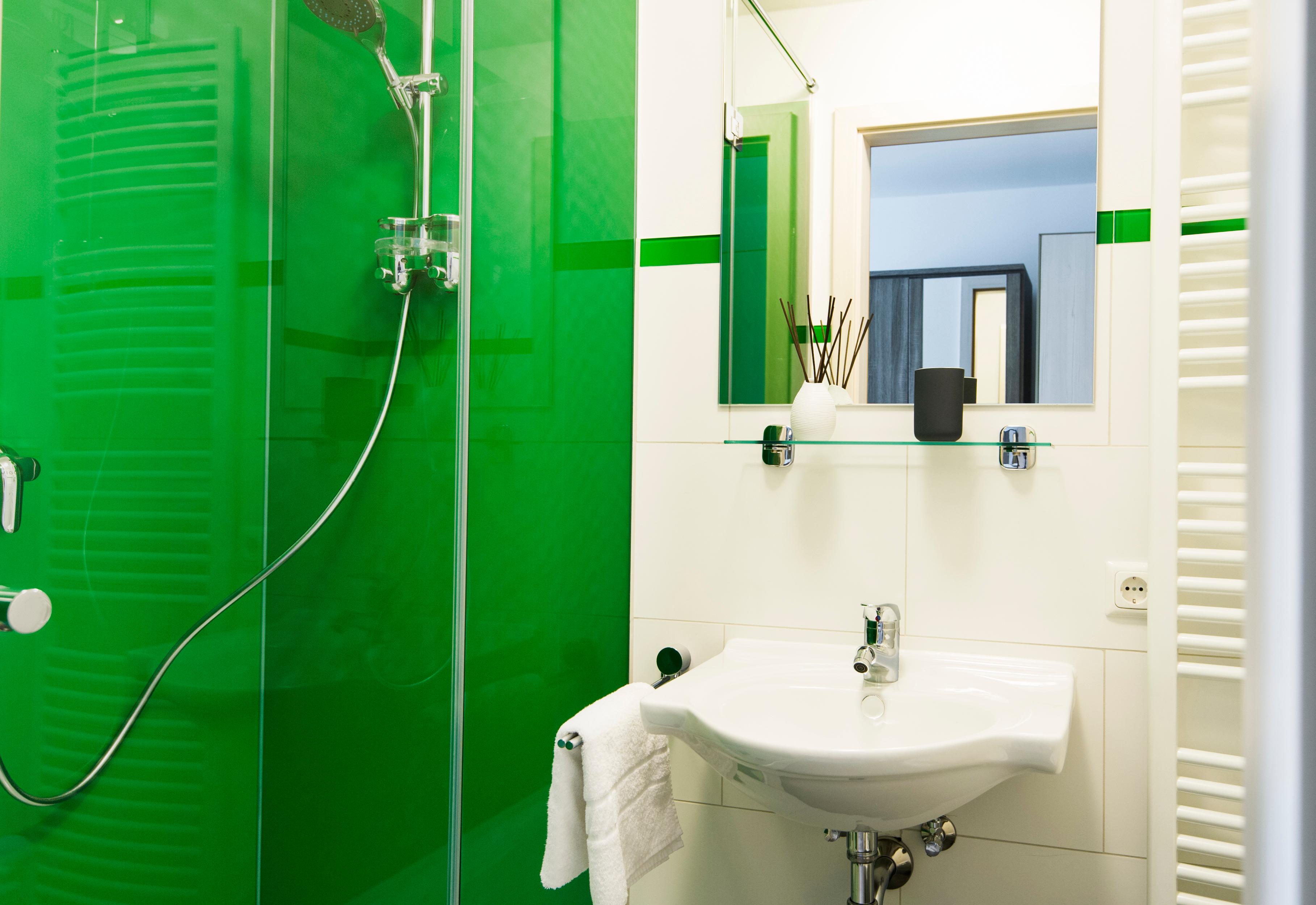 Glas Dusche rückseitig grün lackiert als Duschrückwand #badezimmer #laminat #duschrückwand ©Layerprint.de