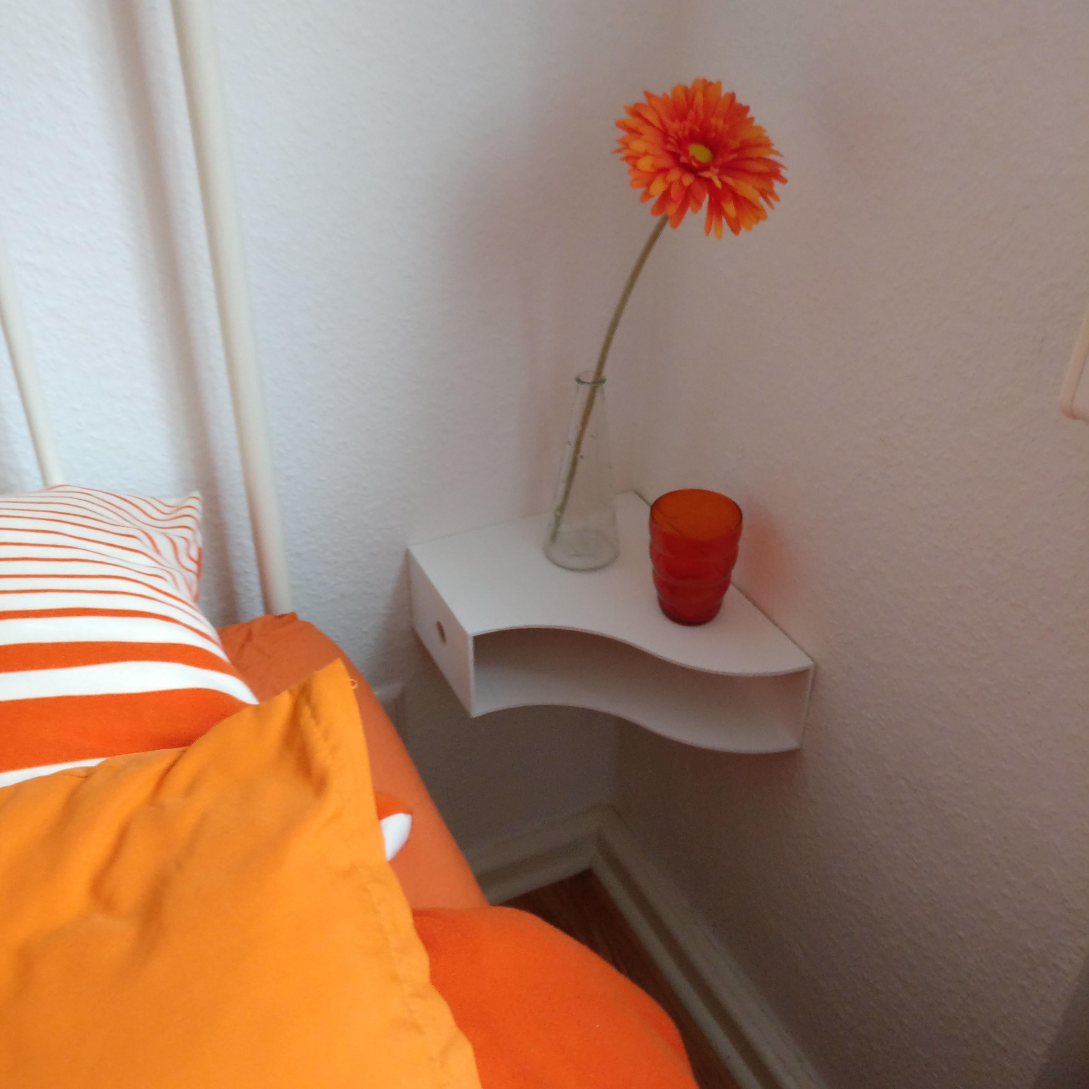 Im kleinen, engen Schlafzimmer war kein Platz für einen Nachttisch. 
Simple Alternative: Wandkonsole aus Magazinsammler.