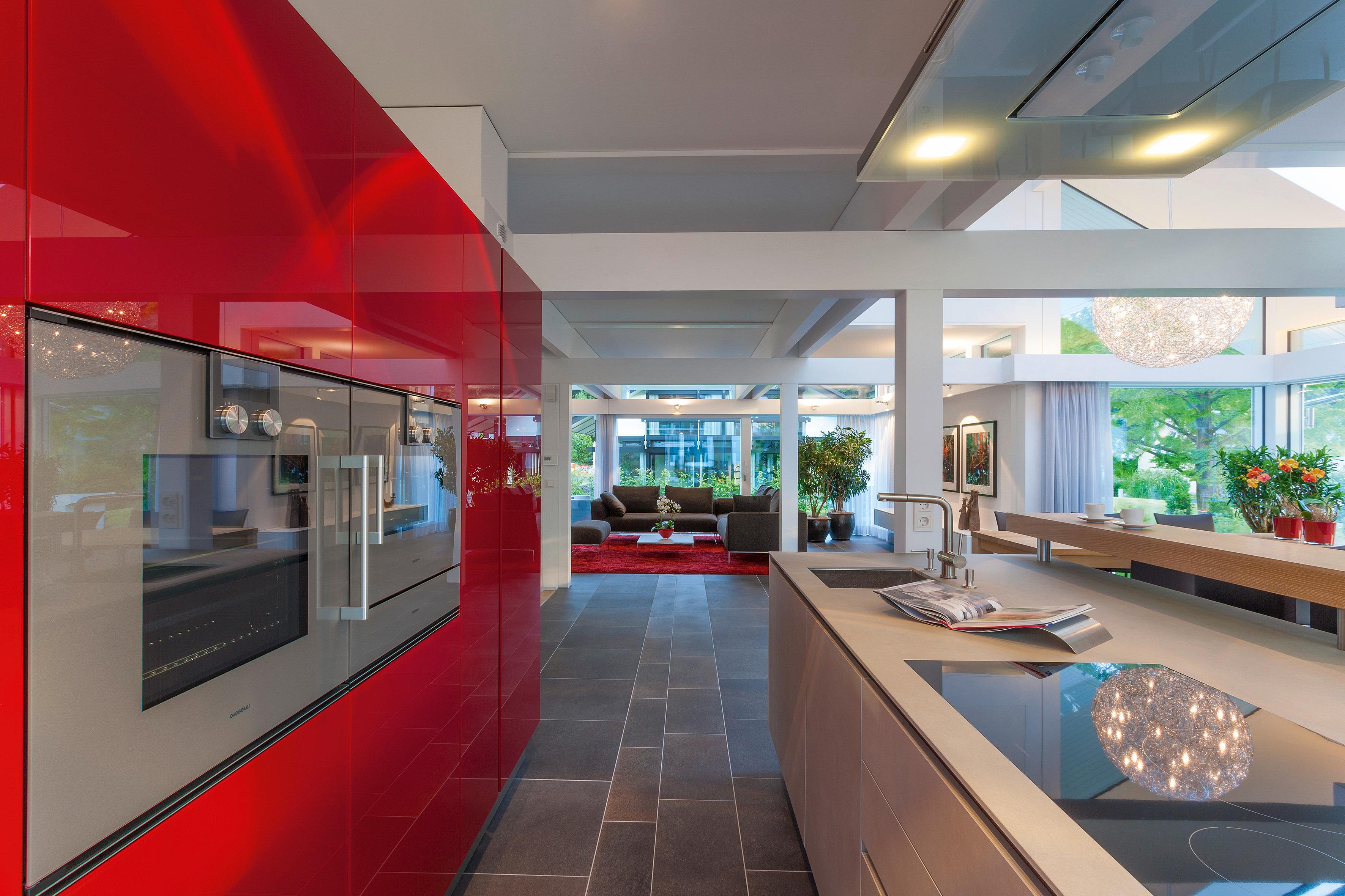 Küche mit stilvoller roter Wand #fliesen #balken #wohnzimmer #waschbecken #kücheninsel #offeneküche #küchenblock #küchentresen #designhaus #spüle #hölzernekücheninsel ©HUF HAUS