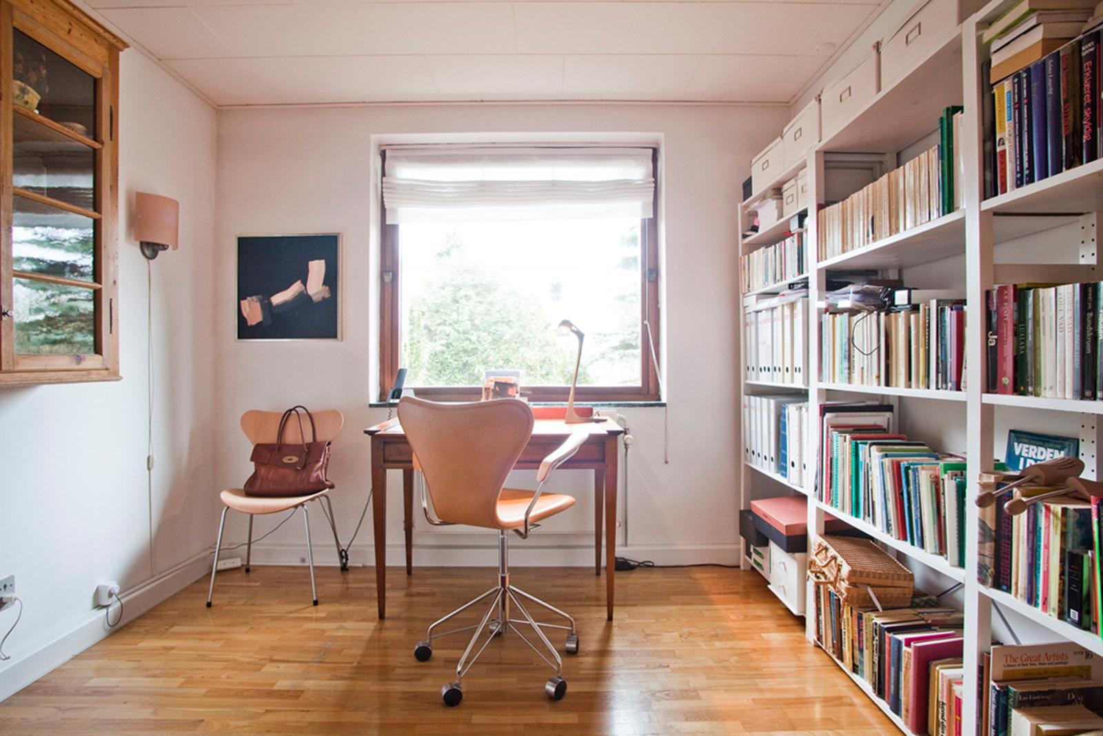 Langes Bücherregal und schicke Designer-Stühle #bürostuhl #wandregal #bücherregal #wandleuchte #laminat #holzarbeitstisch ©Fritz Hansen