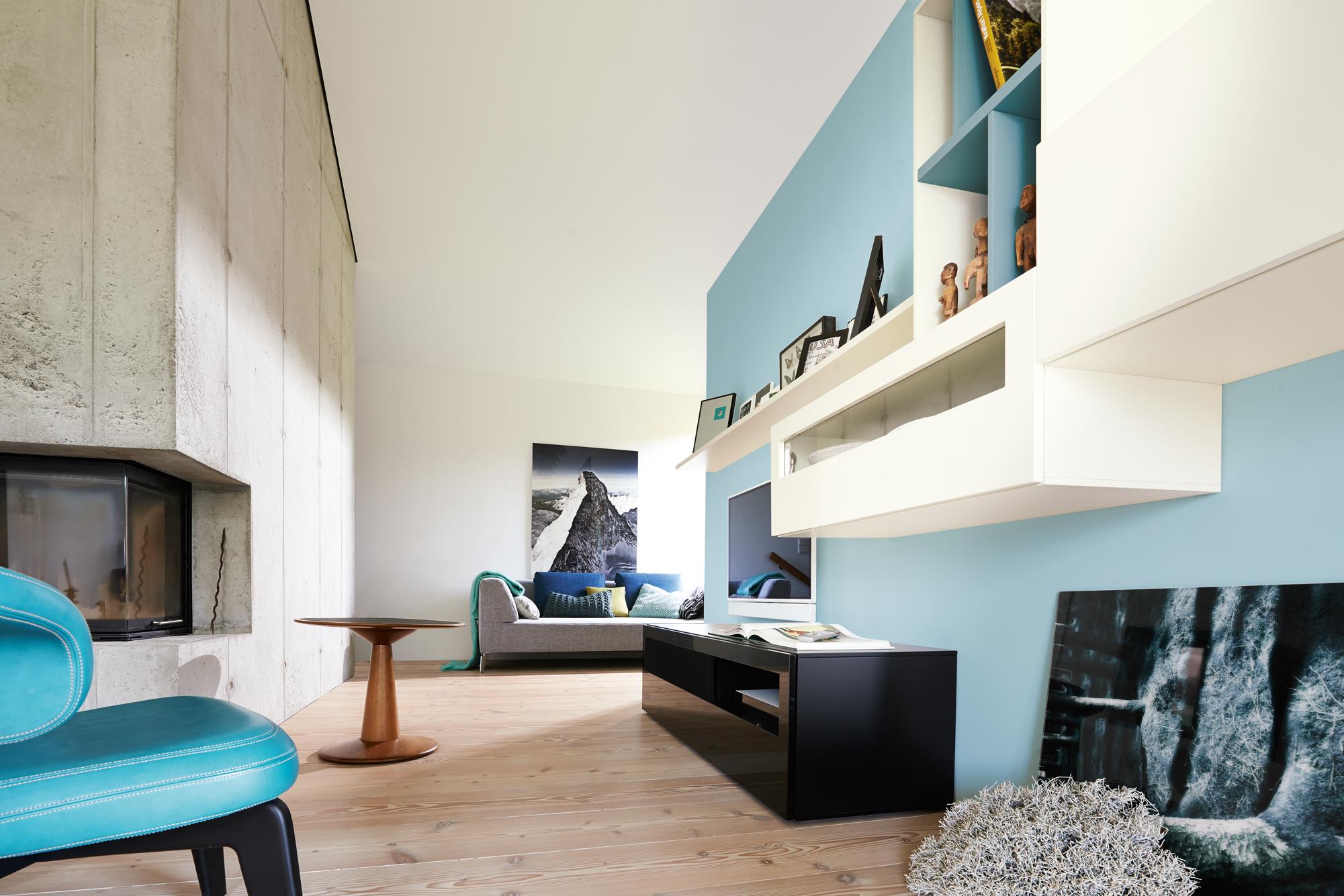 Mit hellblauer Wandfarbe den Raum optisch vergrößern #regal #kamin #sideboard #sofa #hellblauewand #optischvergrößern ©Hülsta