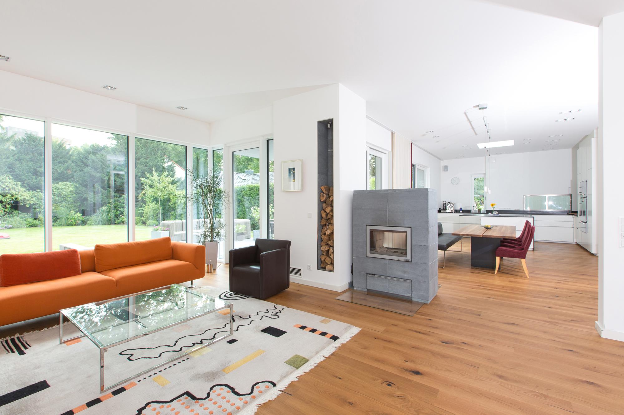 offener Wohn- und Essbereich #bodenbelag #teppich #kamin #orangefarbenessofa ©Jens Lehmkühler