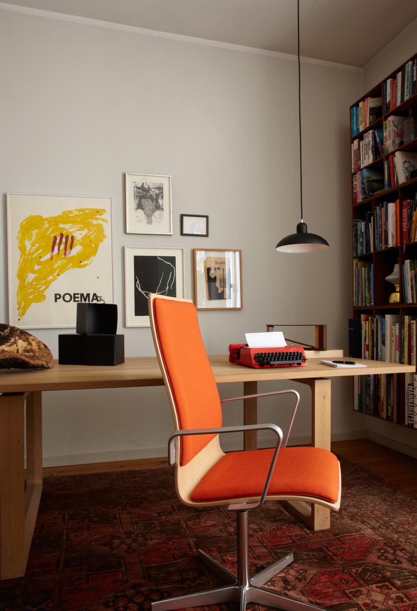 Orangefarbener Bürostuhl zum Eichenholztisch #bürostuhl #holztisch #bücherregal #holzschreibtisch #schwarzehängeleuchte ©Fritz Hansen