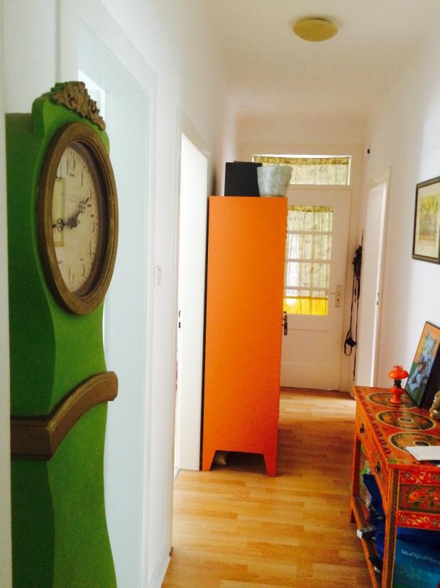 Quietschgrüne Standuhr, Kommode im Asiastil und orangener Metallspind im Flur #homestory