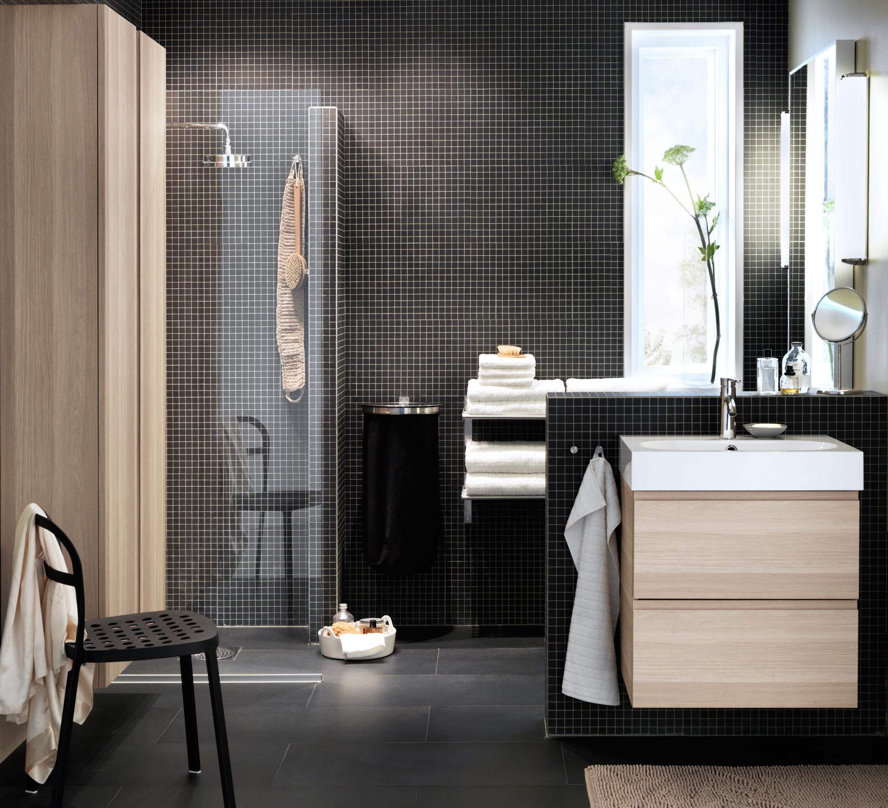 Schwarze Mosaikfliesen und helle Holzschränke im modernen Badezimmer #ikea #holzschrank ©Inter IKEA Systems B.V