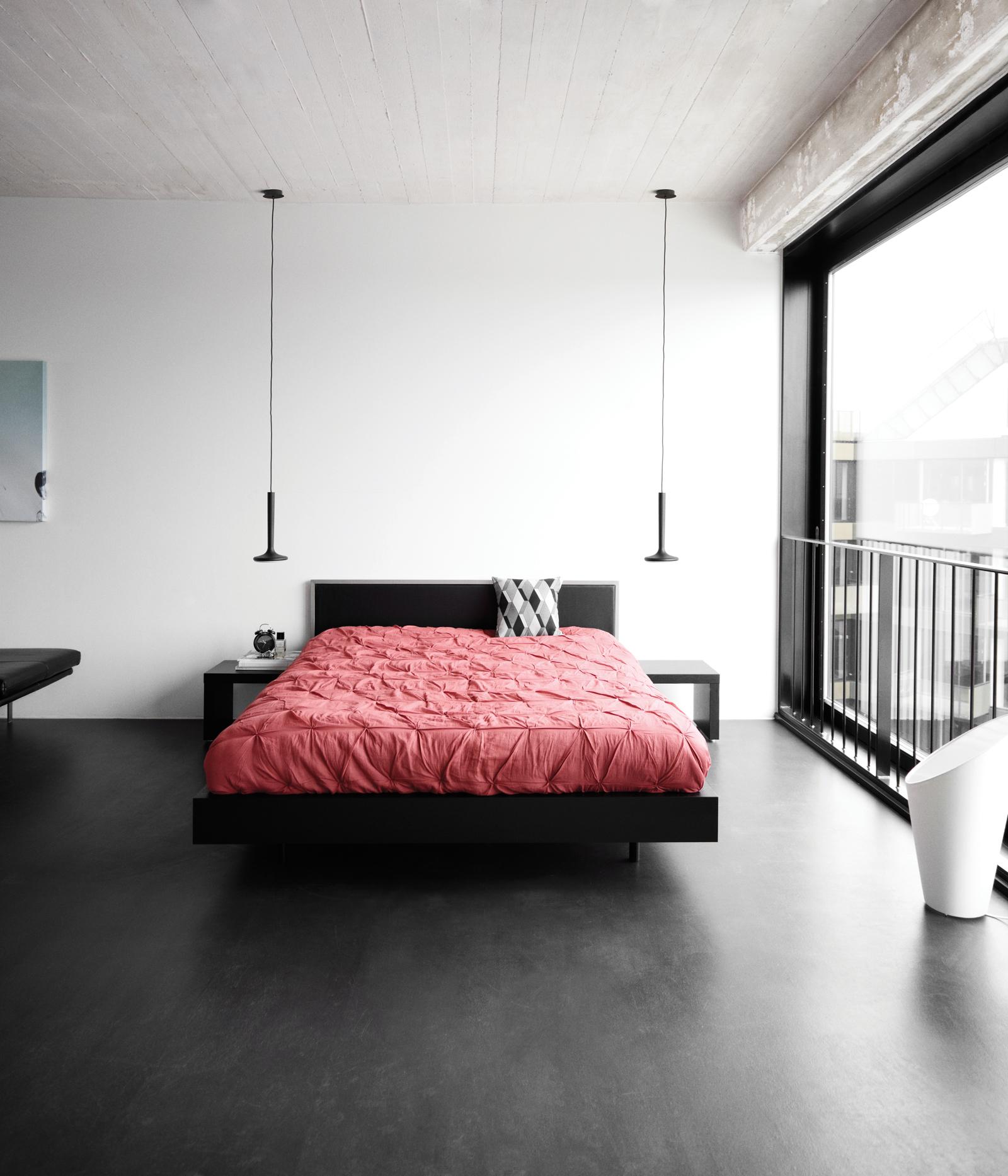 Schwarzes Doppelbett mit roter Bettwäsche #betondecke #schwarzehängeleuchte #boconcept ©BoConcept