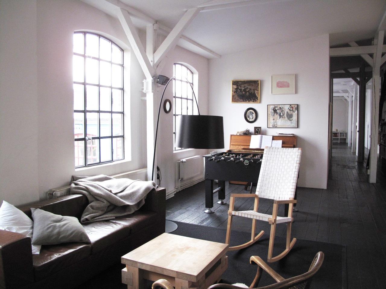 Sitzecke und Kickertisch im Wohnzimmer #bogenlampe #holztisch #schaukelstuhl #sofa #sitzecke ©scout for location