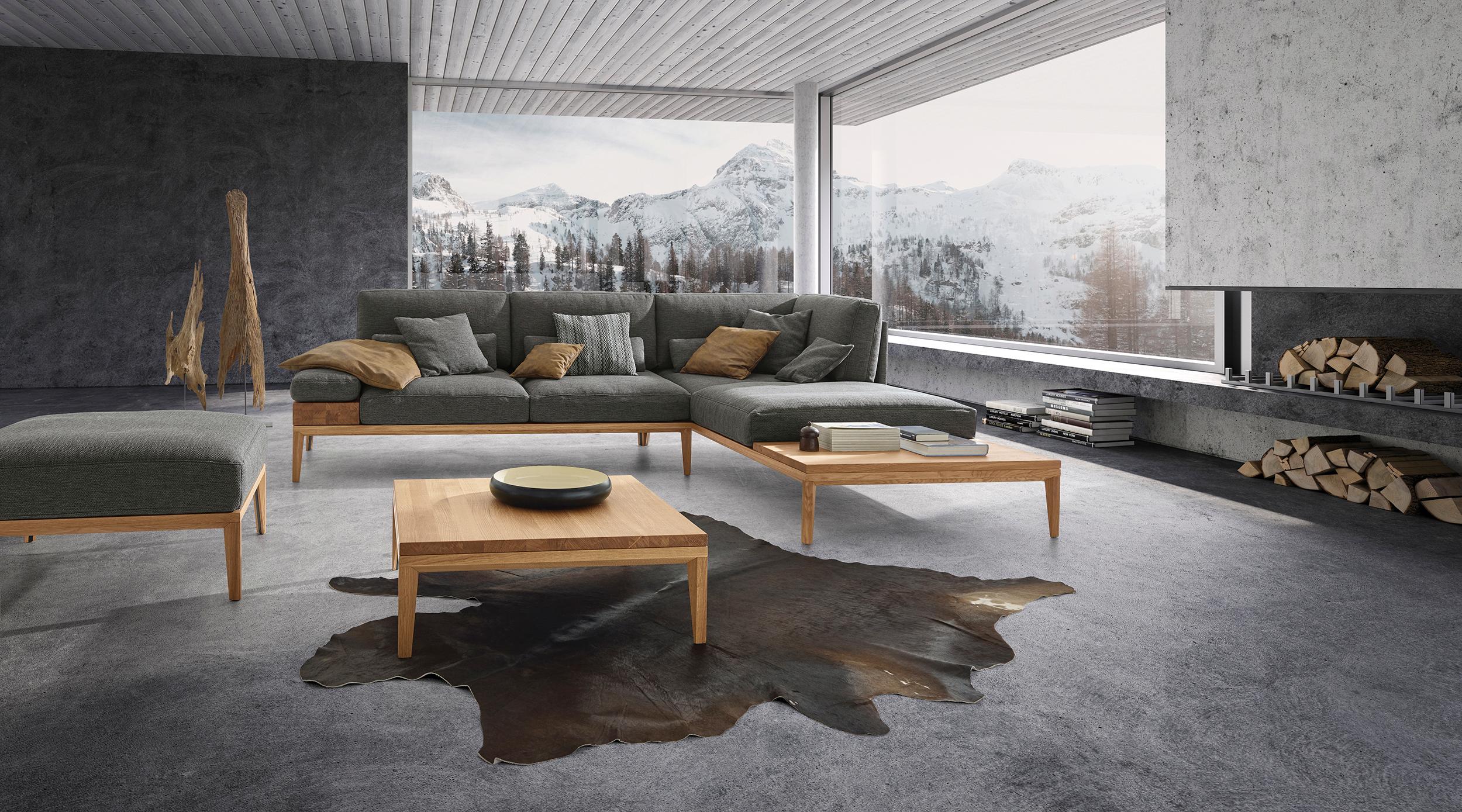 Sofa "Tavola" in Grau mit Holzelementen von ADA #beistelltisch #sofa #grauessofa #holzsofa #wohnzimmergestaltung #panoramafenster ©ADA