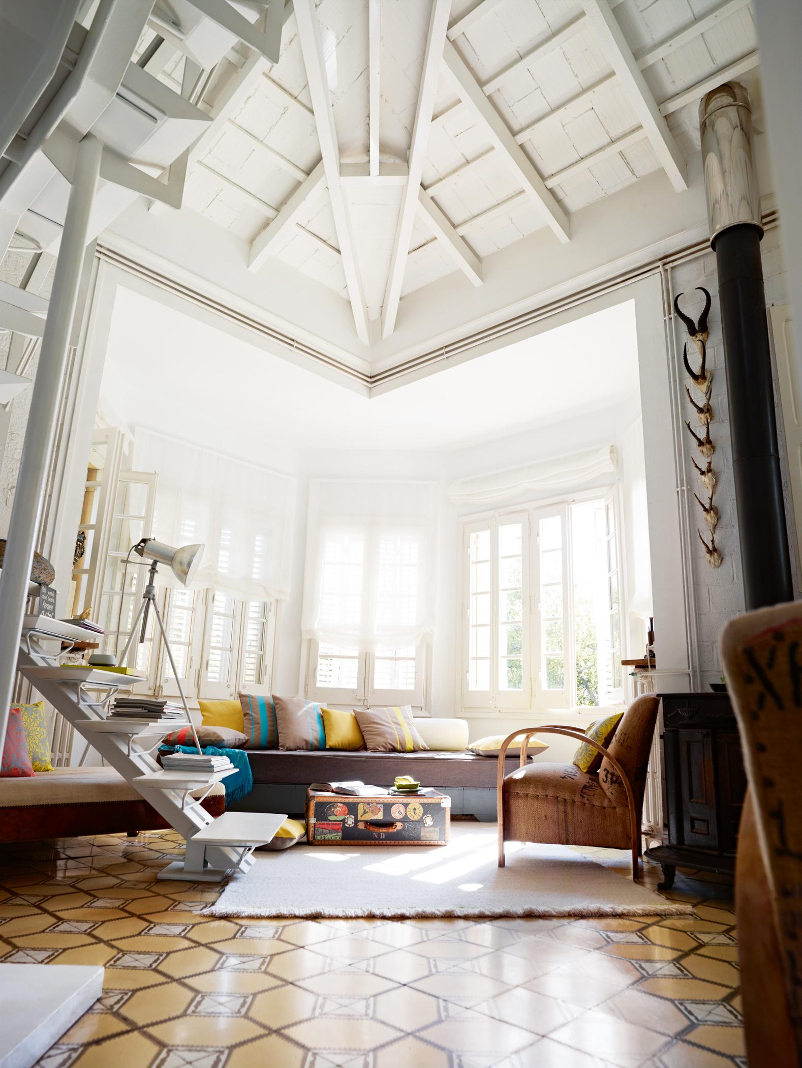Umfunktionierte Treppe im Wohnzimmer #eklektisch #deckenbalken #sofakissen #bodenfliesen #braunessofa ©Esprit Home, Ofen