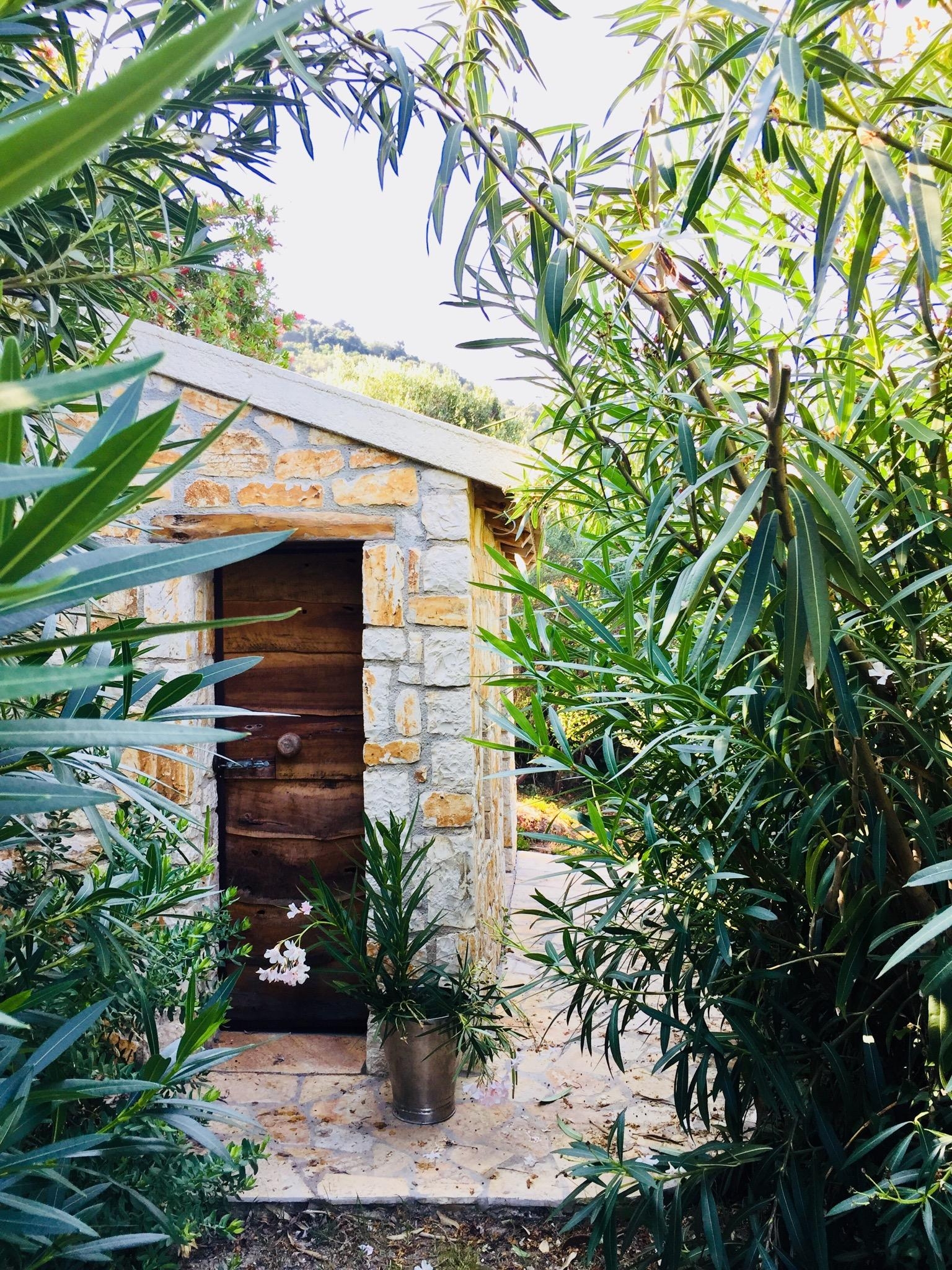 Unsere Gartenhütte zwischen Oleanderbüschen #steinhaus #oleander #olivenholz #holztür #natursteinmauer #greekstyle 