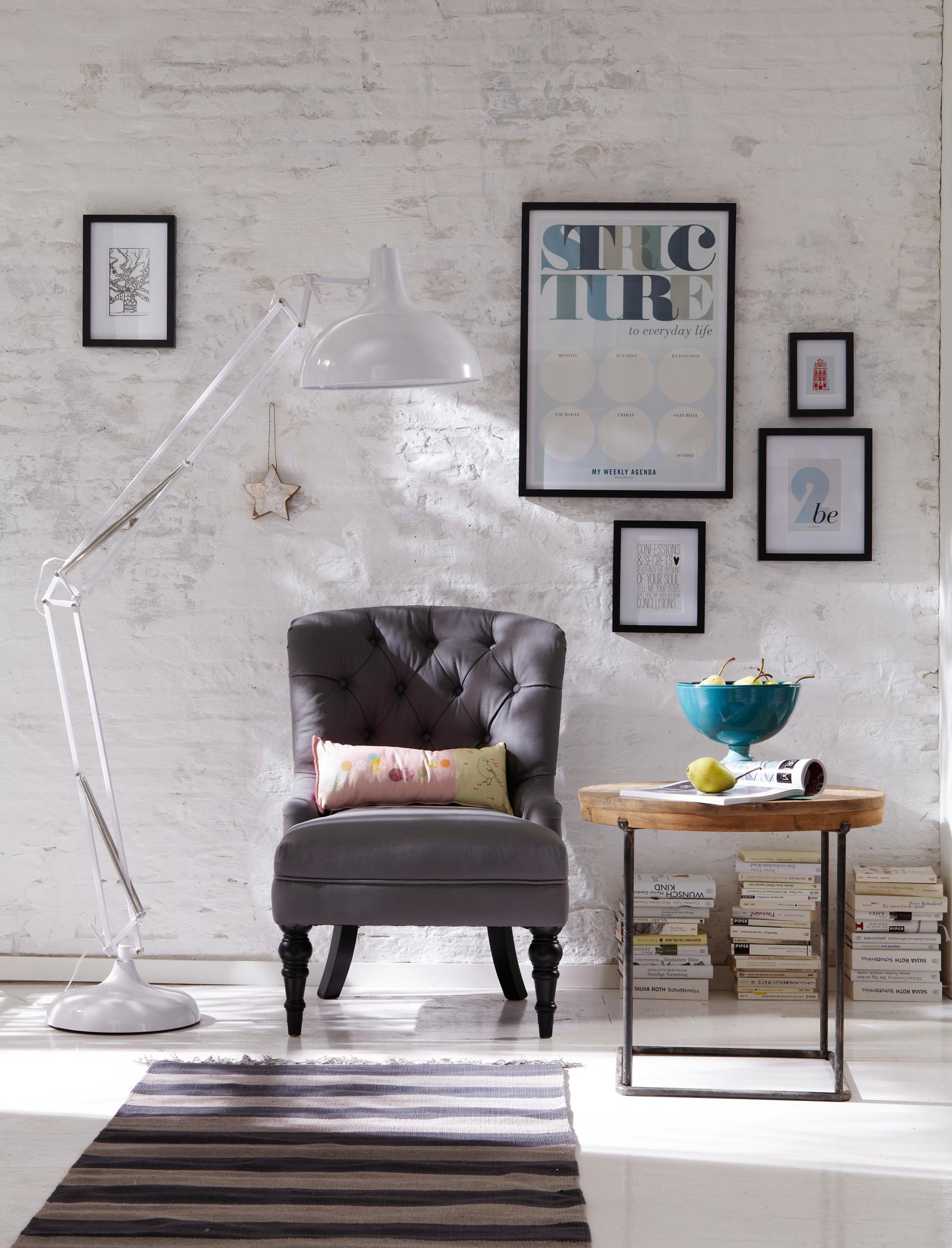 Weiße Stehleuchte und grauer Lounge-Sessel im modernen Wohnzimmer #beistelltisch #shabbychic #industriedesign #gestreifterteppich #obstschale #weißesteinwand ©Car Selbstbaumöbel