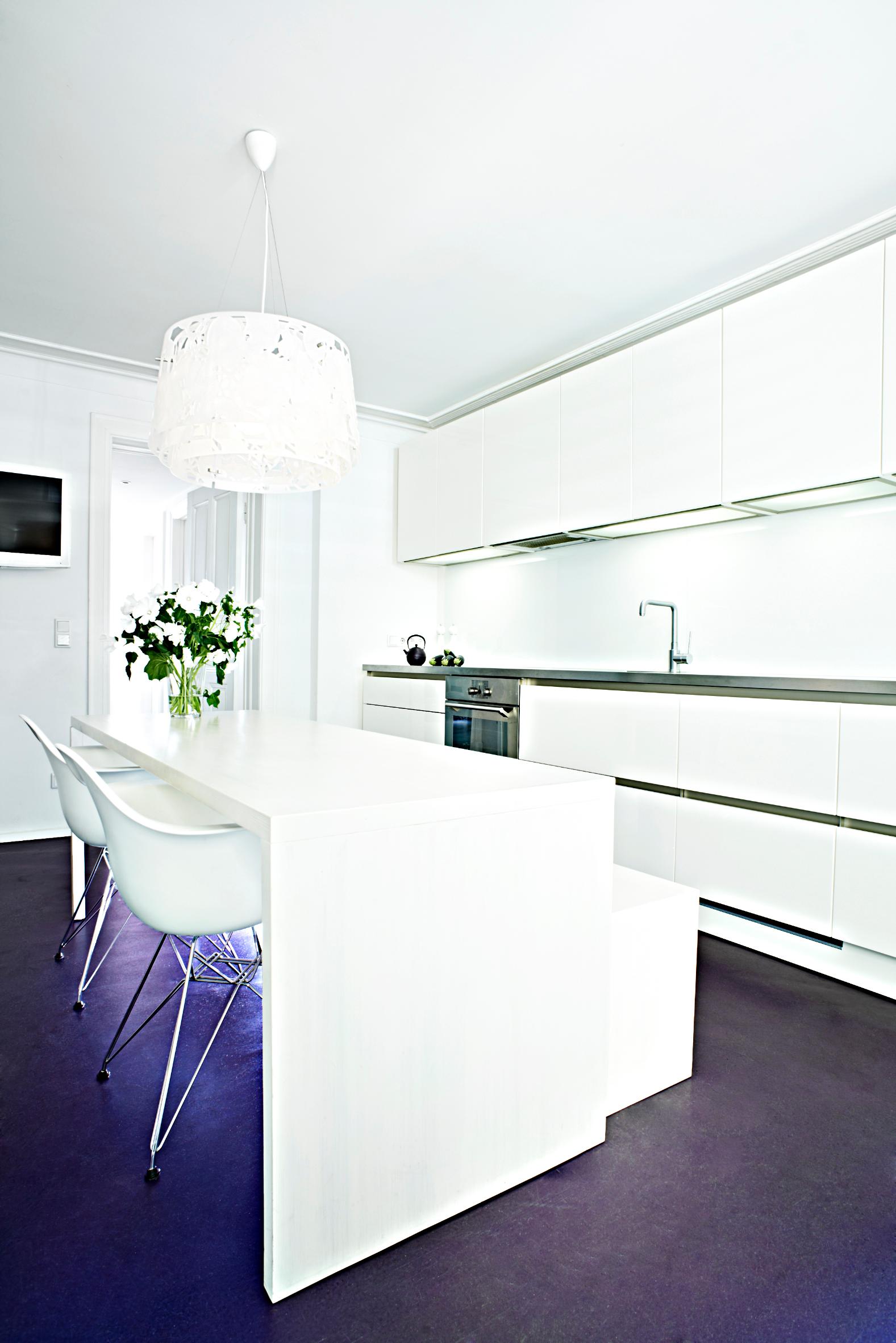 Wohnküche in weiß Hochglanz lackiert, grifflos, mit Edelstahlarbeitsplatte #weißerküchenschrank #küchentisch ©burmester photography
