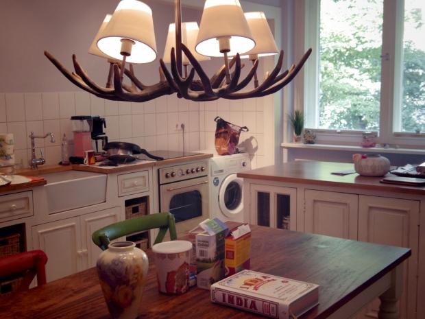 Wohnküche mit Geweihleuchter, Arbeitsinsel und Keramikspüle. #homestory