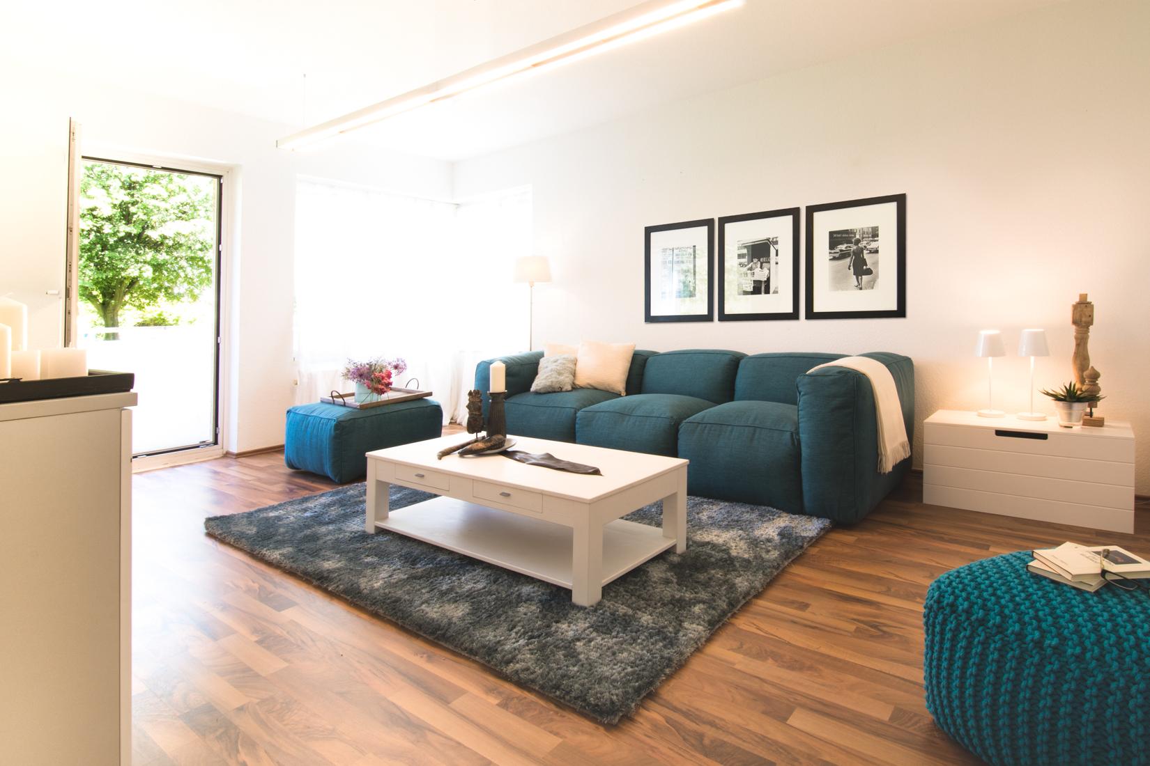 Wohnzimmer #couchtisch #teppich #pouf #sofa #blauessofa #weißercouchtisch #wandbild #tisch ©Luna Homestaging