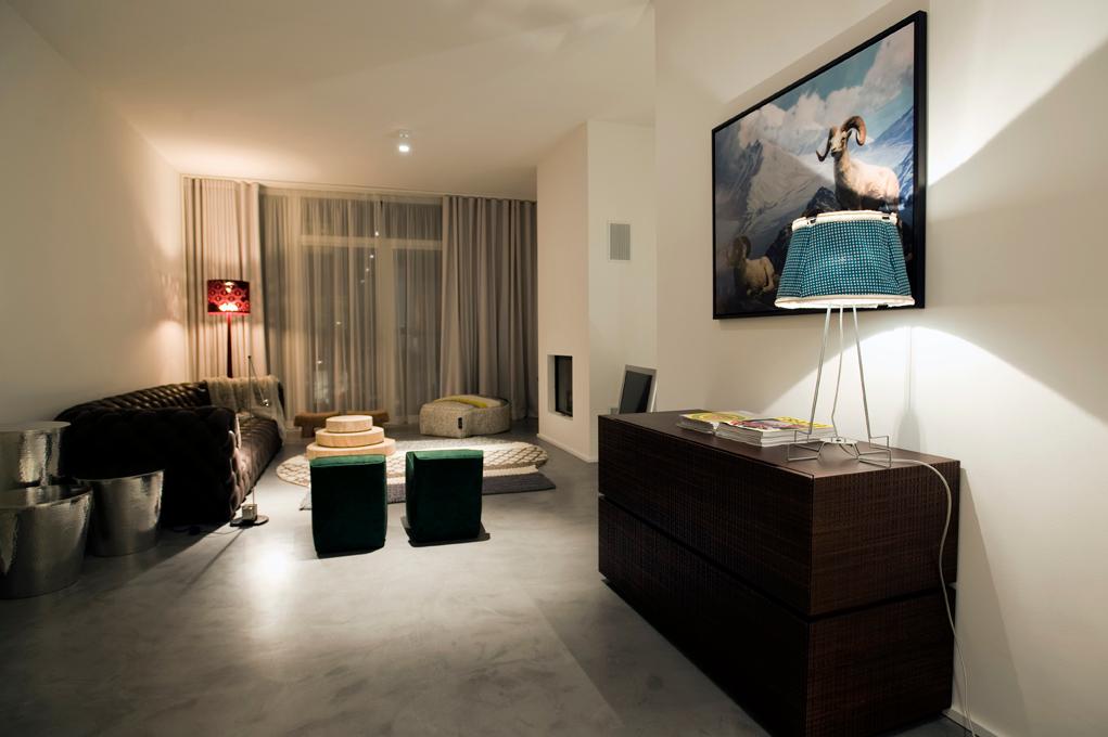 Wohnzimmer mit Alpenpanorama #beistelltisch #hocker #teppich #kamin #wohnzimmer #stehlampe #sideboard #vorhang #sofa #tischlampe ©POPO GmbH