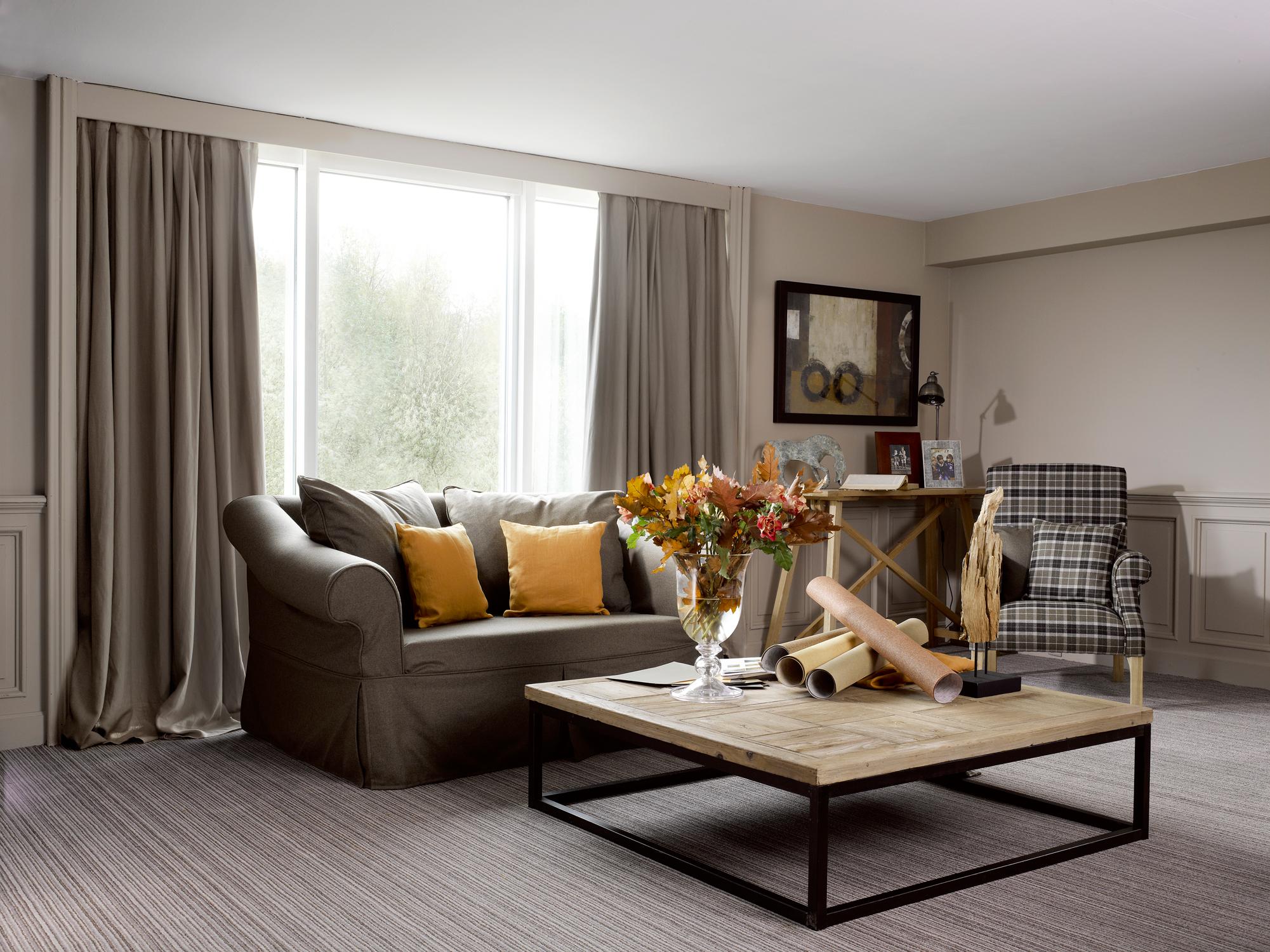 Wohnzimmer mit natürlichen Farbtönen gestalten #couchtisch #teppich #sessel #vorhang #wandspiegel #zimmergestaltung ©Flamant